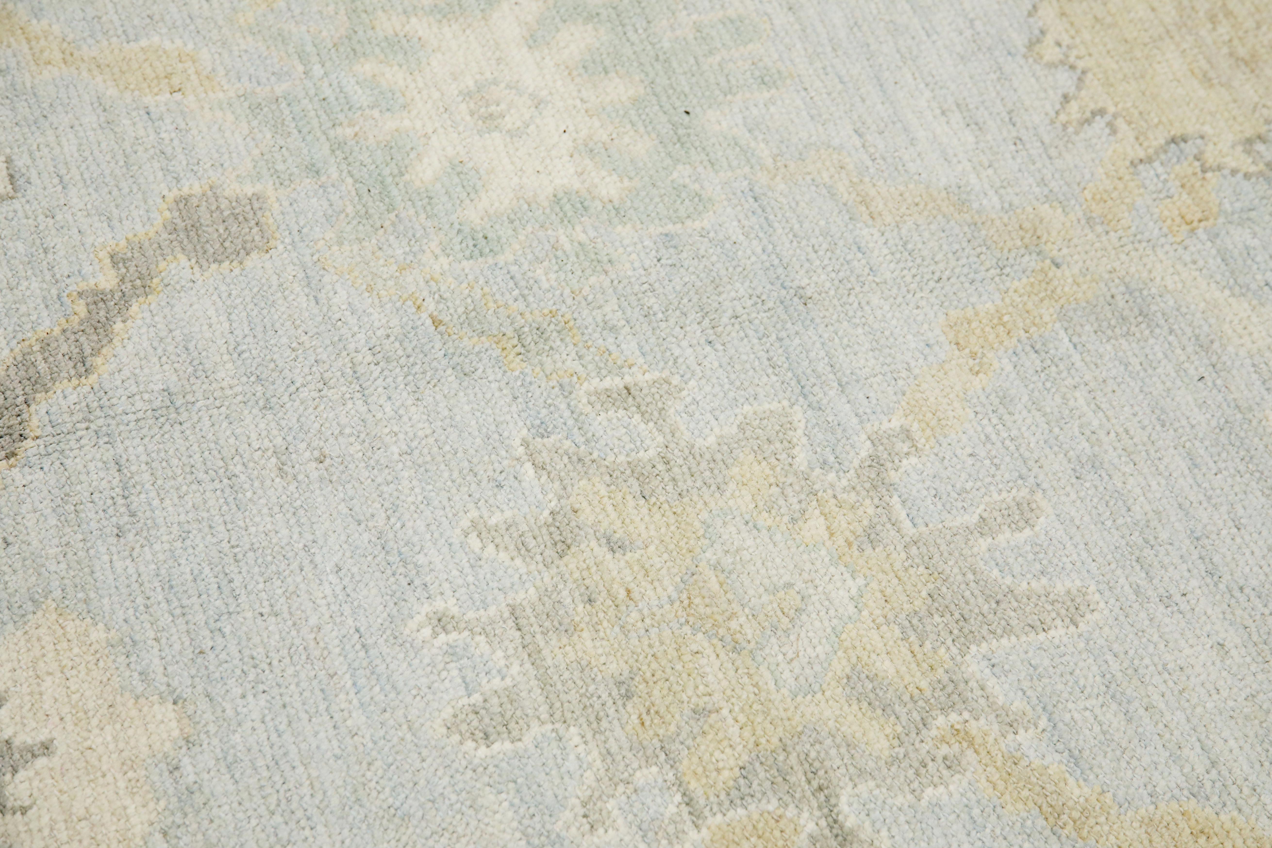This modern Turkish Oushak rug is a stunning piece of art that has been handwoven using traditional techniques by skilled artisans. The rug features intricate patterns and a soft color palette that is achieved through the use of natural vegetable