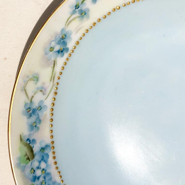 Round pale French blue garden motif porcelain saucer, bread plate, dessert plate or vide poche by Haviland France. This beautiful rare floral ceramic saucer is decorated with relief around the inside edge with garlands and bouquets of blue and very