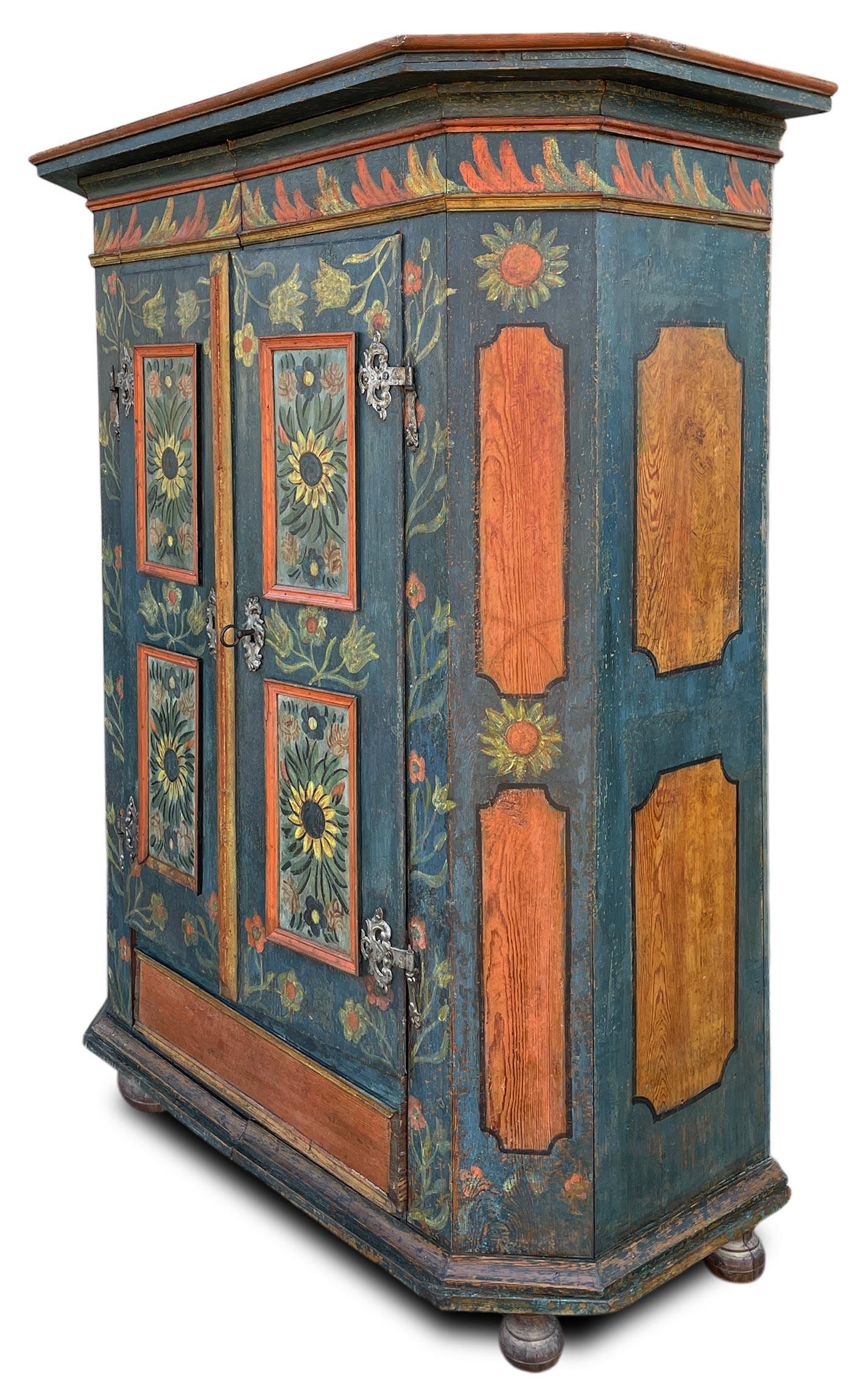 Alpinblau bemalter Kleiderschrank mit Sonnenblumen

Maße: H. 183 cm - B. 128 (150 bis zu den Rahmen) cm - T. 55 (66 bis zu den Rahmen) cm
Zeitraum: Spätes 18. Jahrhundert
Herkunft: Bayerische Alpen
Holz: Tanne

Beschreibung:
Zweitüriger