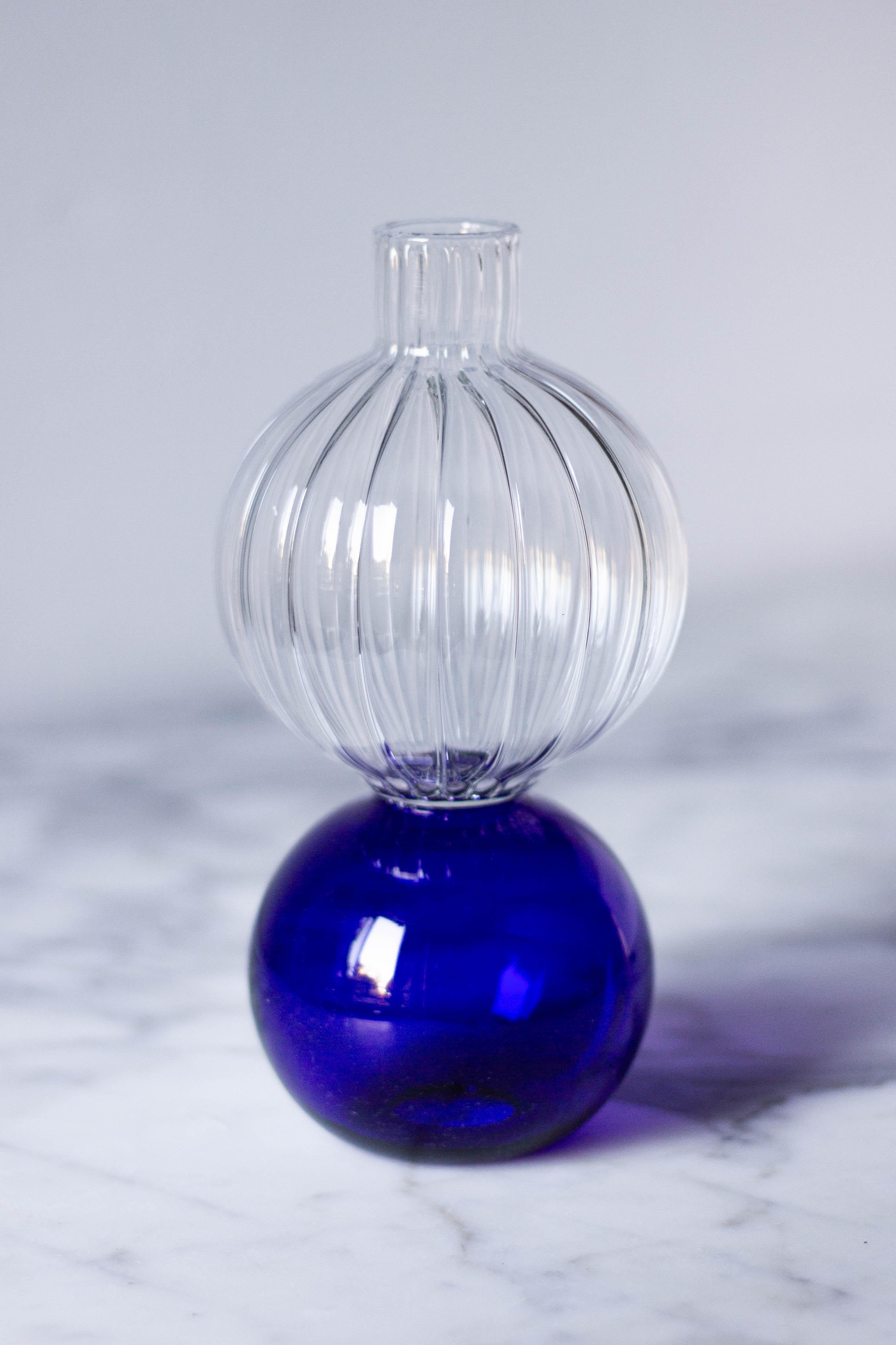 Dieser handgefertigte Wasserbehälter ist ein exquisites Stück aus der Wonder Crystal Collection und besticht durch die Verschmelzung von klaren und blauen Farbtönen. Der kunstvoll geblasene Kristall verfügt über einen kugelförmigen Sockel, der