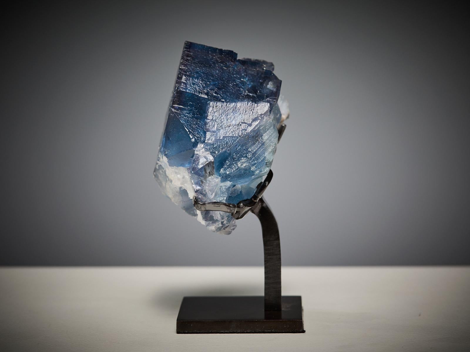 This striking specimen from La Viesca mine, La Collada, Huergo, Siero, Asturias, Spain features a magnificent deep blue fluorite cube beautifully accented by a delicate layer of white quartz crystals. The fluorite exhibits superb transparency, sharp