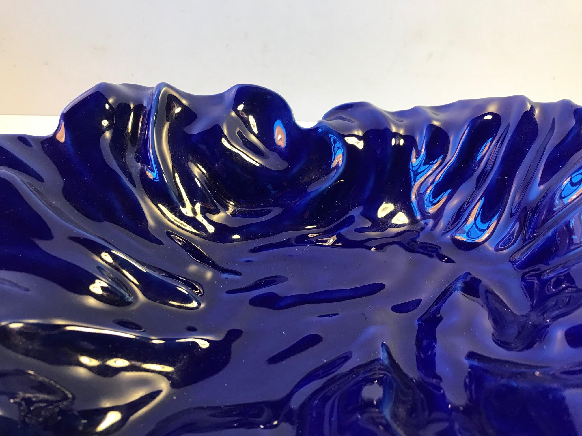 Cobalt blue glazed faience bowl by danish designer Ole Kortzau. It is called Natura due to its freeform shape. The is a piece from the 1990s and its stamped by Royal Copenhagen.