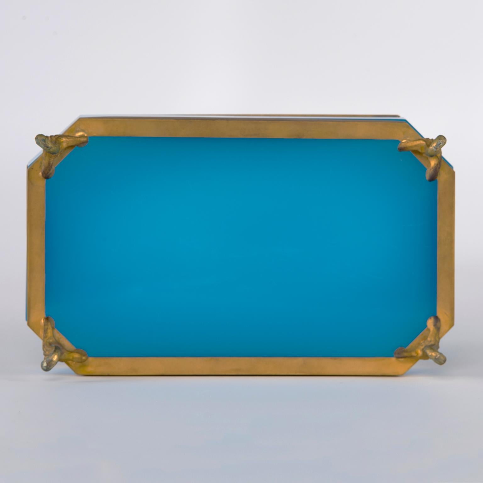 French opaline glass box is a stunning shade of marine blue with brass at the rim and base and brass cabriole feet, circa 1920s. Unknown maker.