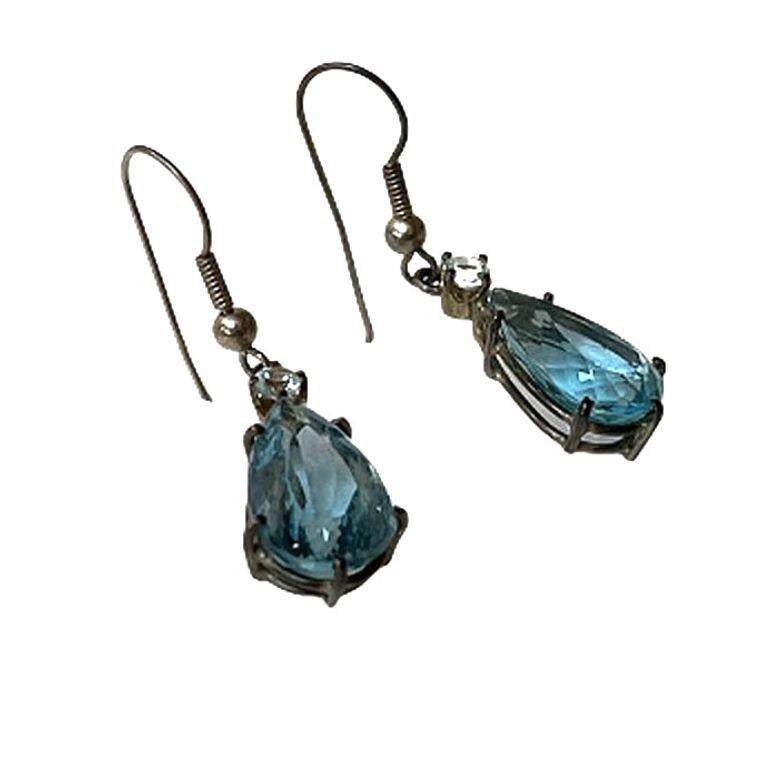 This is a pair of earrings made from sterling silver and a blue topaz-type of stone, which has been heavily faceted. They are a wonderful aqua blue that glistens in the light reminiscent of peridot or the ocean on a perfect summer day.

The
