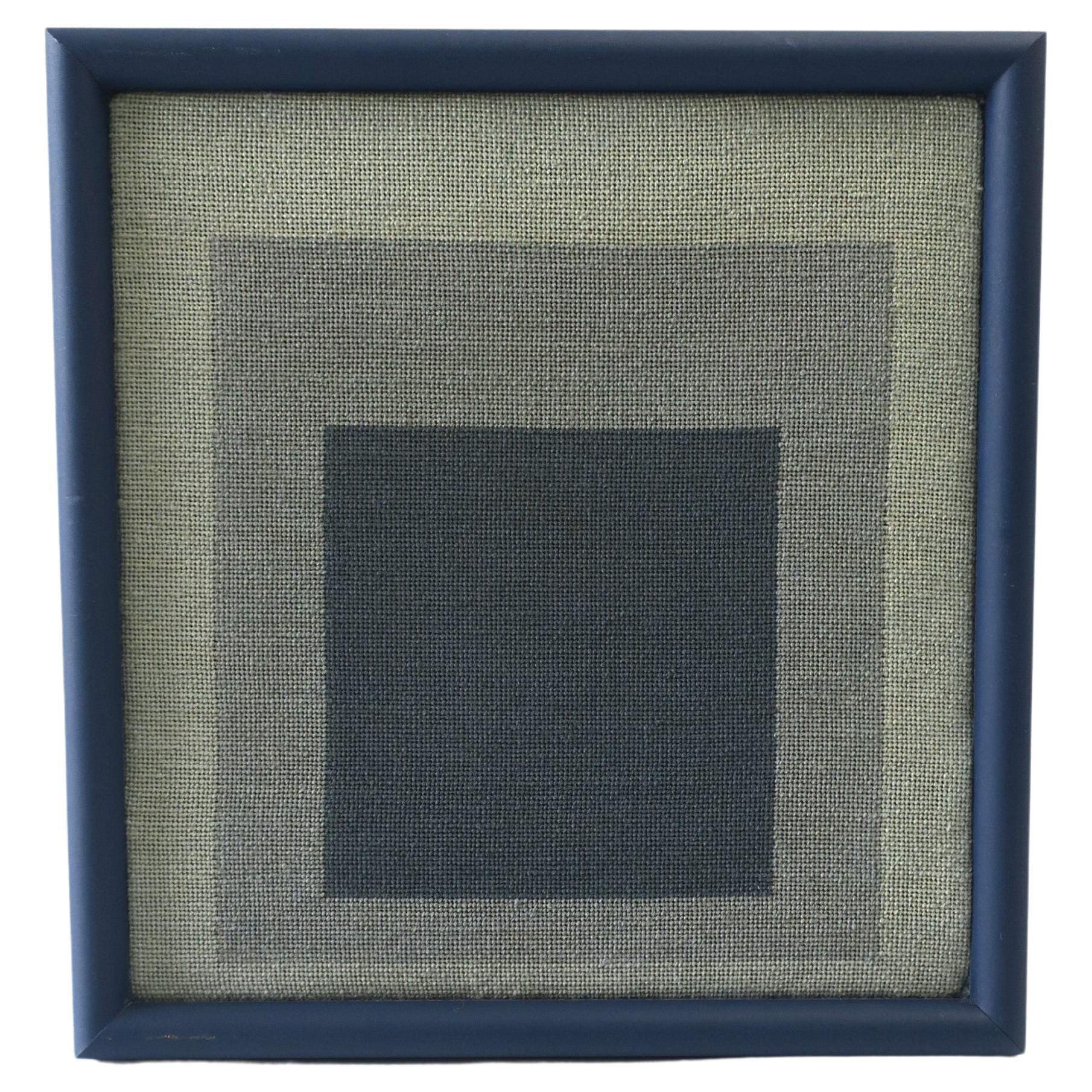A blue geometric needlepoint artwork wall art styled after German artist, Josef Albers, circa late-20th century. This needlepoint piece is admiration to Albers' 'Homage to the Square' painting artwork from the 1950s. This artwork has a powder coated