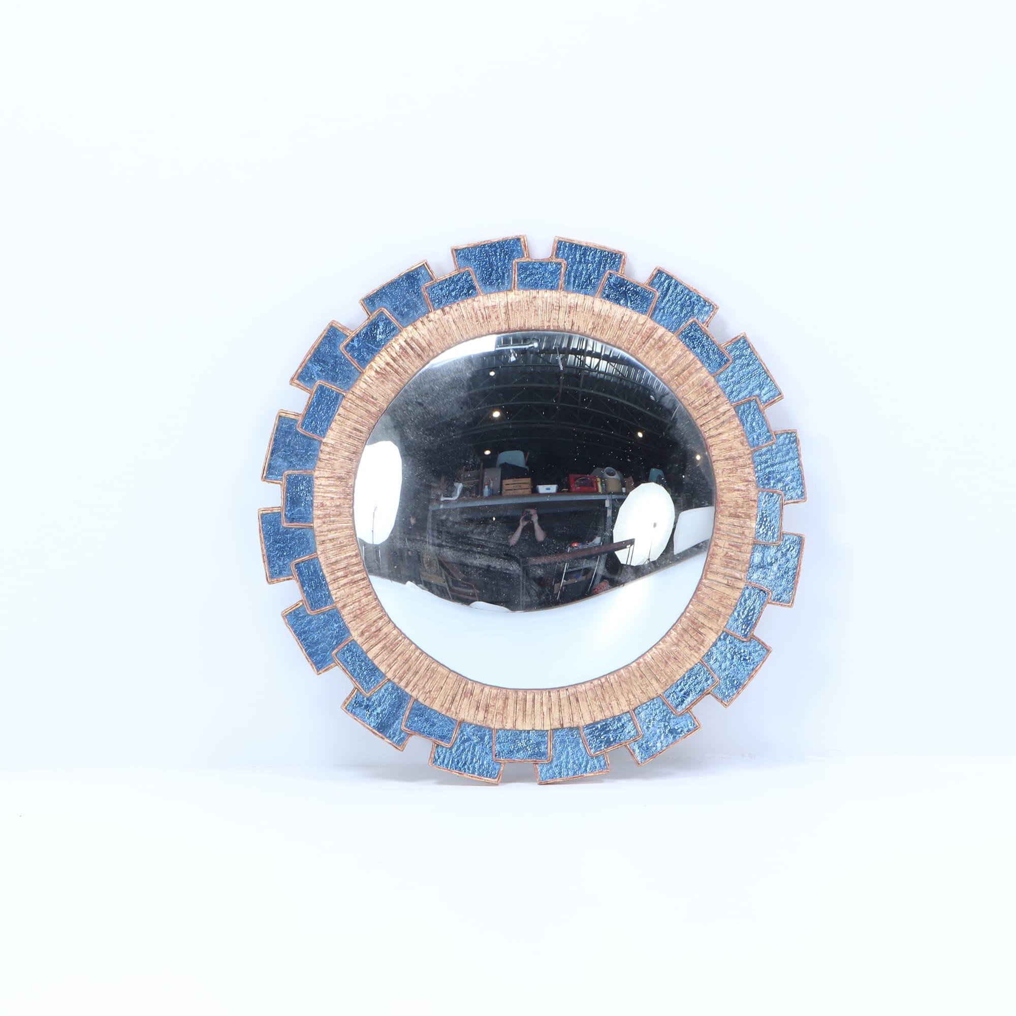 A blue glass and resin convex mirror having textured glass arranged in a geometric fashion in the manner of Line Vautrin. Contemporary. These mirrors are made by hand by an artist and can be made to order. 