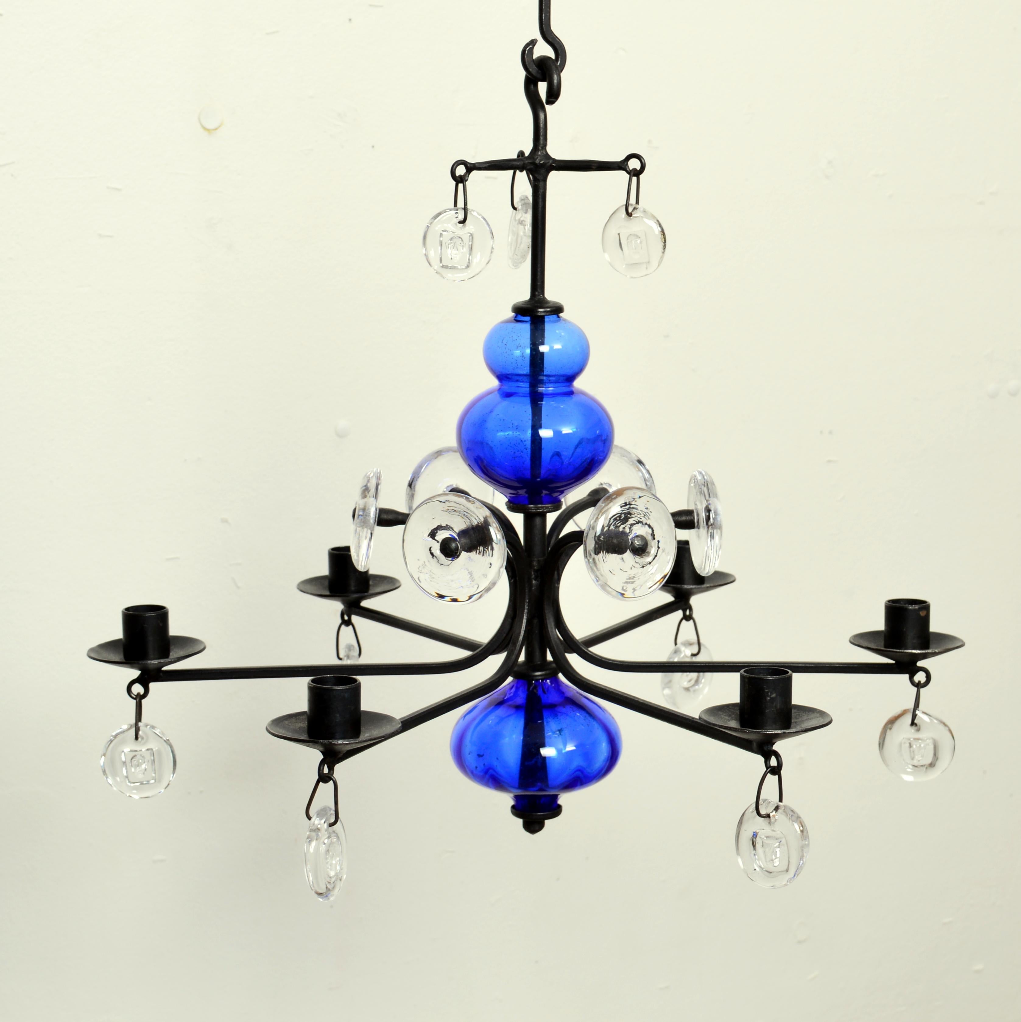 Ce magnifique lustre candélabre en verre d'art bleu et transparent sur fer forgé a été conçu par Erik Höglund pour Boda Smide. Erik Höglund (1932-1998) était l'une des étoiles les plus brillantes de la verrerie suédoise du XXe siècle. Ce lustre à