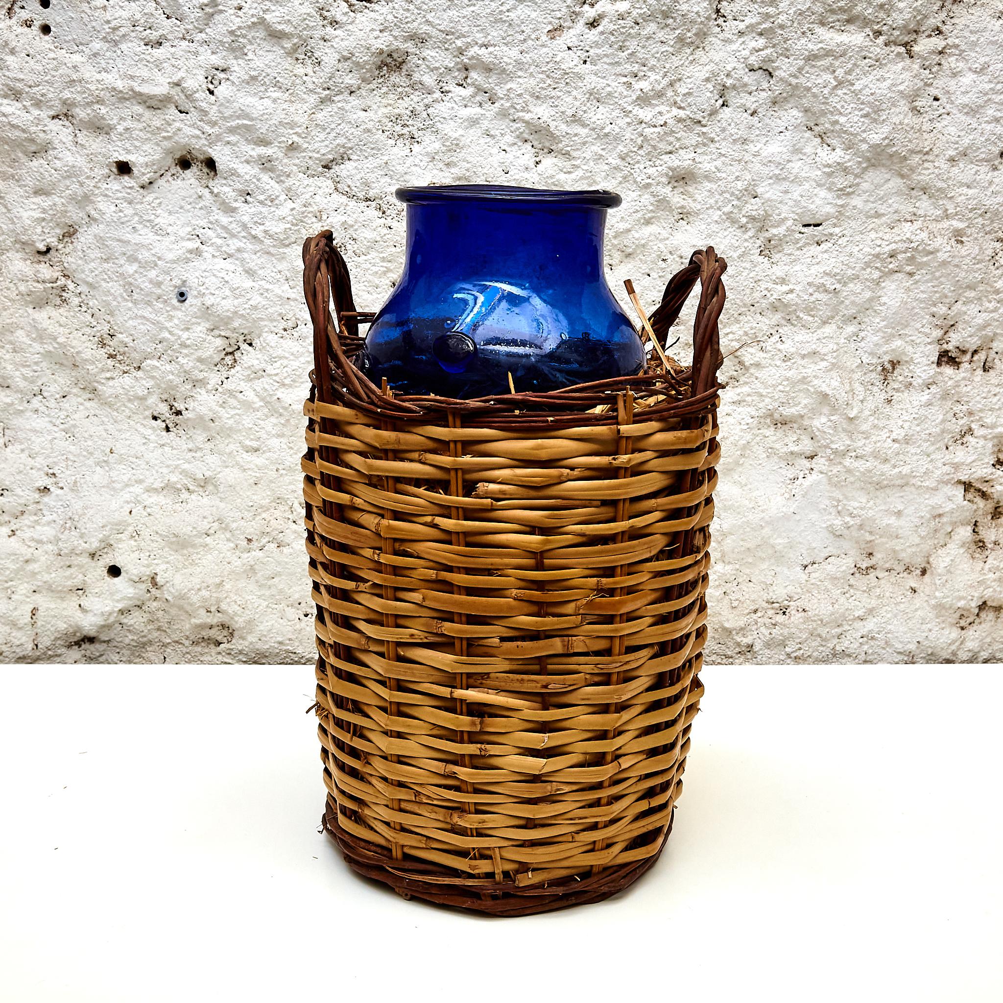 Blue glass bottle with wicker basket.

Manufactured in France, circa 1930.

In original condition with minor wear consistent of age and use, preserving a beautiful patina.

Materials: 
Glass, wicker.

Dimensions: 
Basket: Diam. 24 cm x H