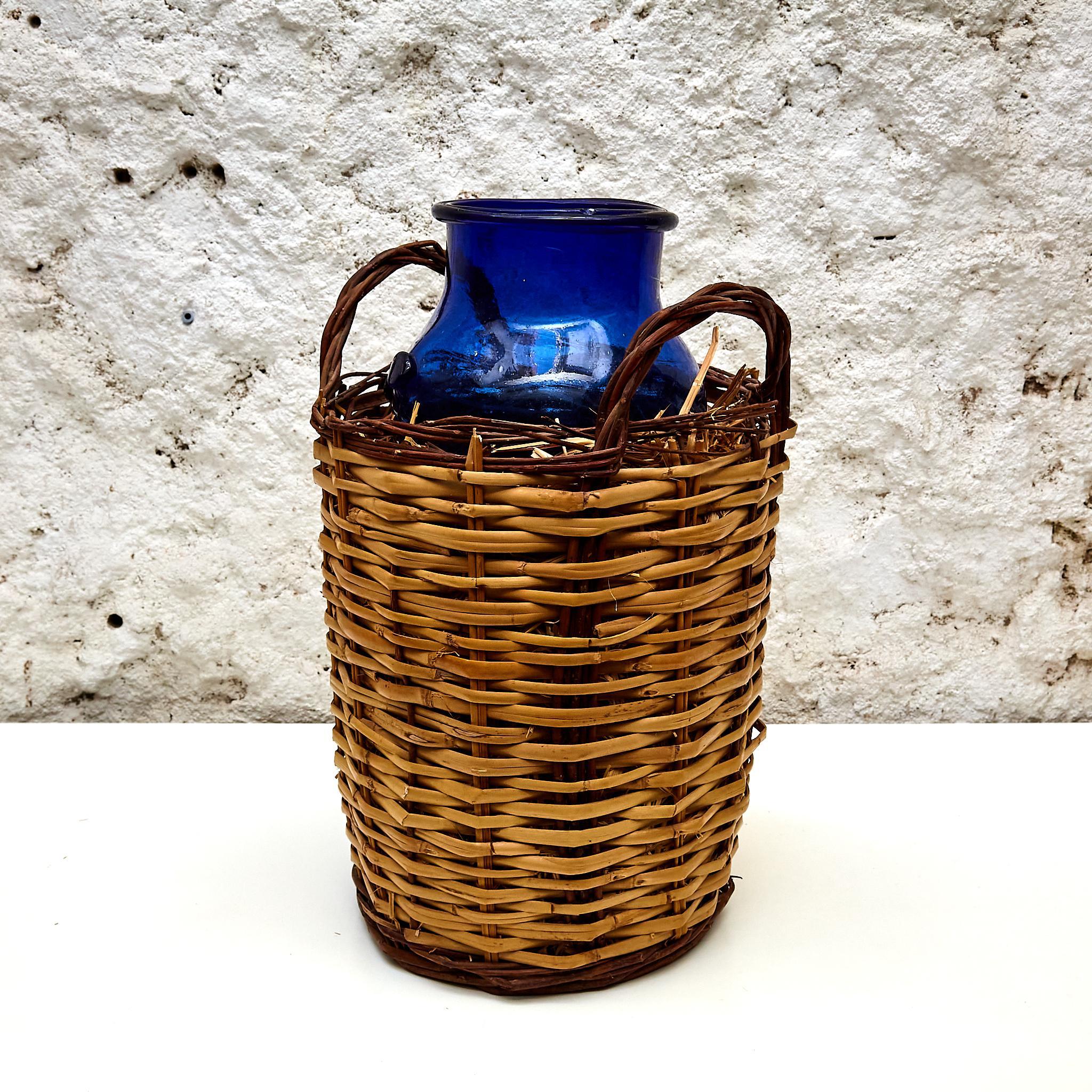 Rustic Blue Glass Bottle with Wicker Basket, circa 1930 For Sale