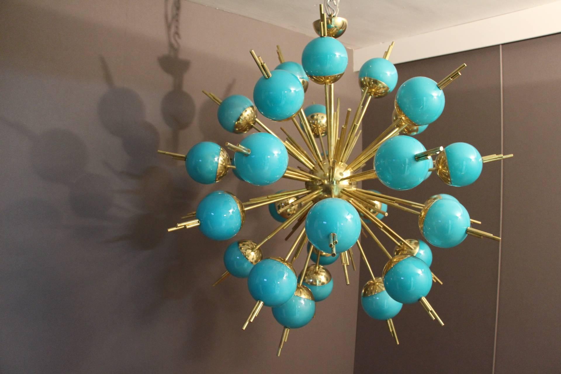 This very unusual Sputnik chandelier features 30 turquoise glass globes mounted on brass rods.
When the light is on, its turquoise globes turn to light blue color and it is still magnificent.