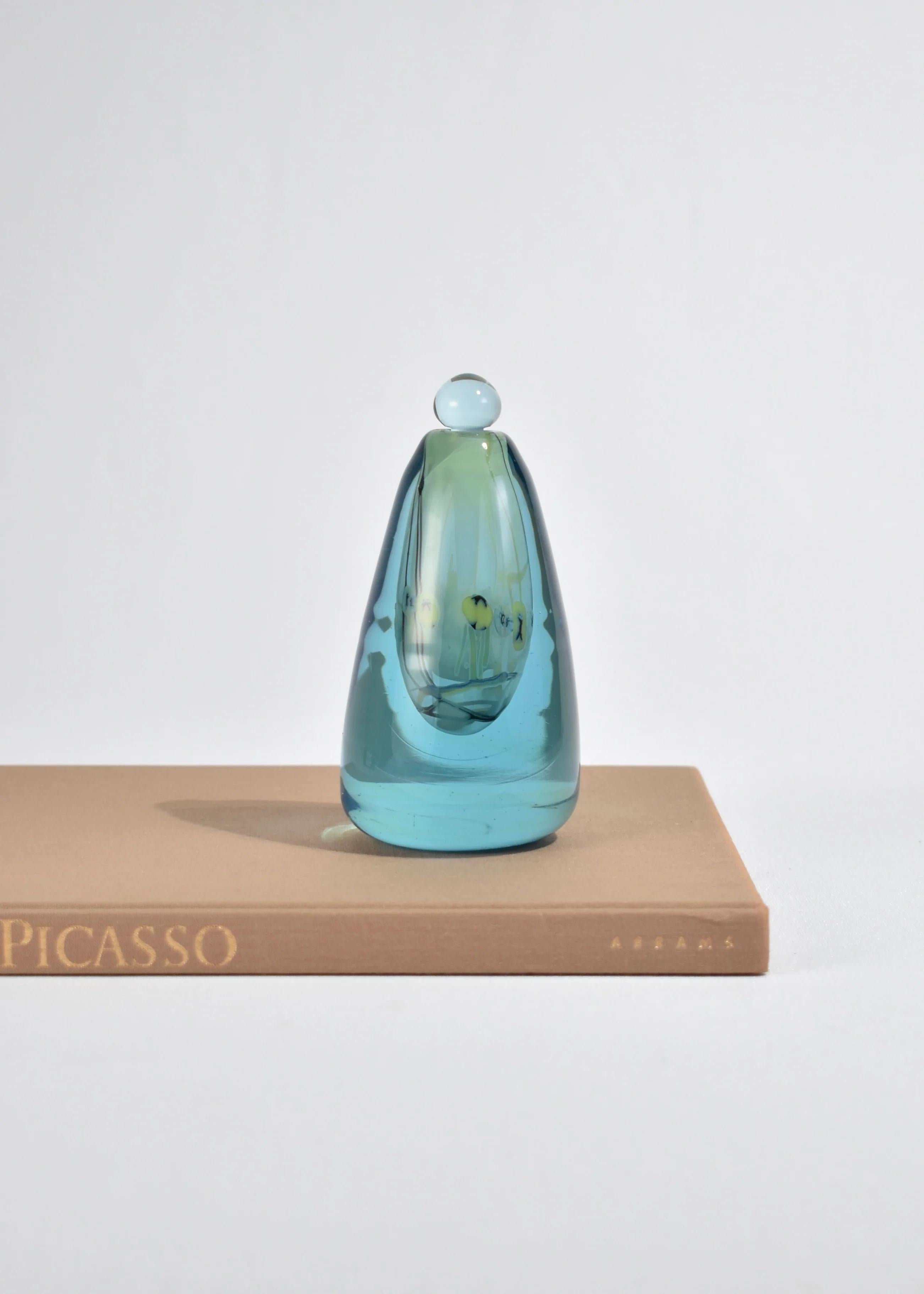 Stunning vintage blown glass perfume bottle in blue with an interior opalescent abstract design. Etched on base, Robert William Bartlett 78-141.