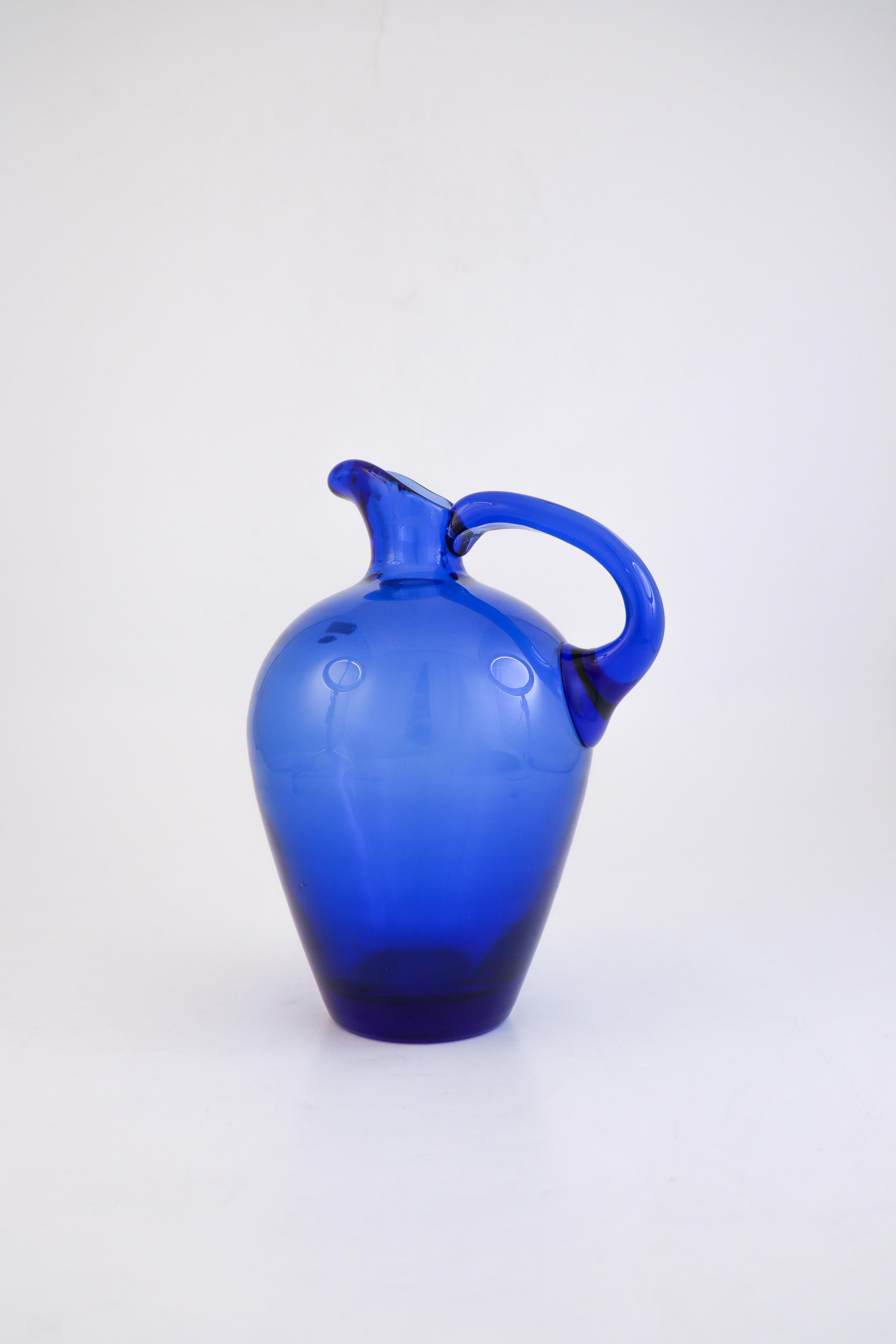 A stunning blue glass pitcher designed at Reijmyre in the 1950s by Monica Bratt. The pitcher is 23.5 cm tall and in best condition. It is label marked as the photo shows. 

