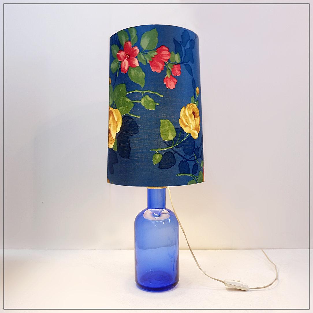 Lámpara de mesa de cristal azul con pantalla original de flores - Años 60
colores decoración - lámpara vintage
Medidas : lámpara :  Ø 13cm H:35cm 
Con Pantalla : Ø 28cm H:70cm 
Desgaste propio de la edad y el uso : ver fotos