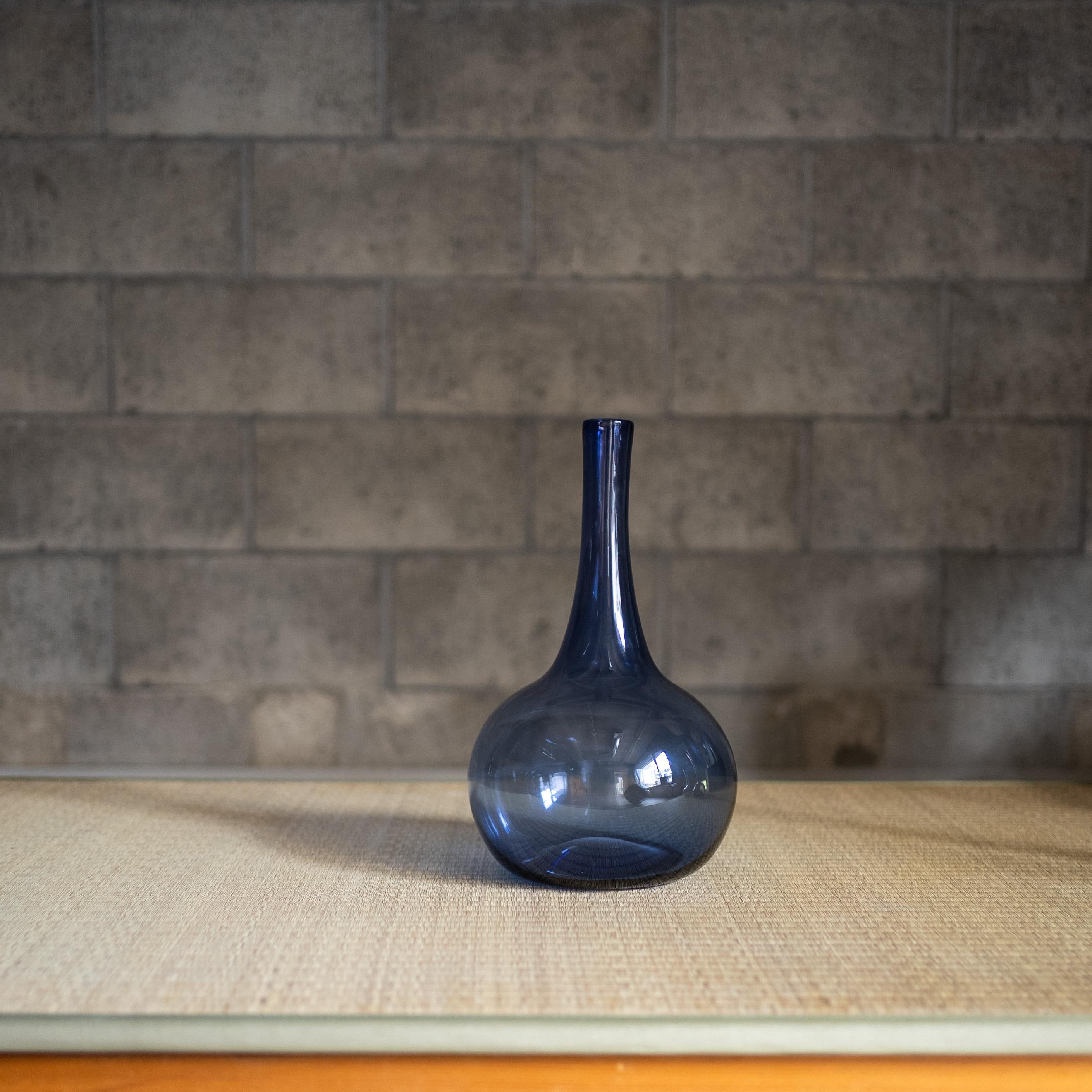 Un raffinato vaso in vetro soffiato a mano dell'artista francese Claude Morin. Il pezzo presenta un elegante collo lungo e un corpo arrotondato in una profonda tonalità di blu cobalto, che cattura la luce con sottili trasparenze e naturali