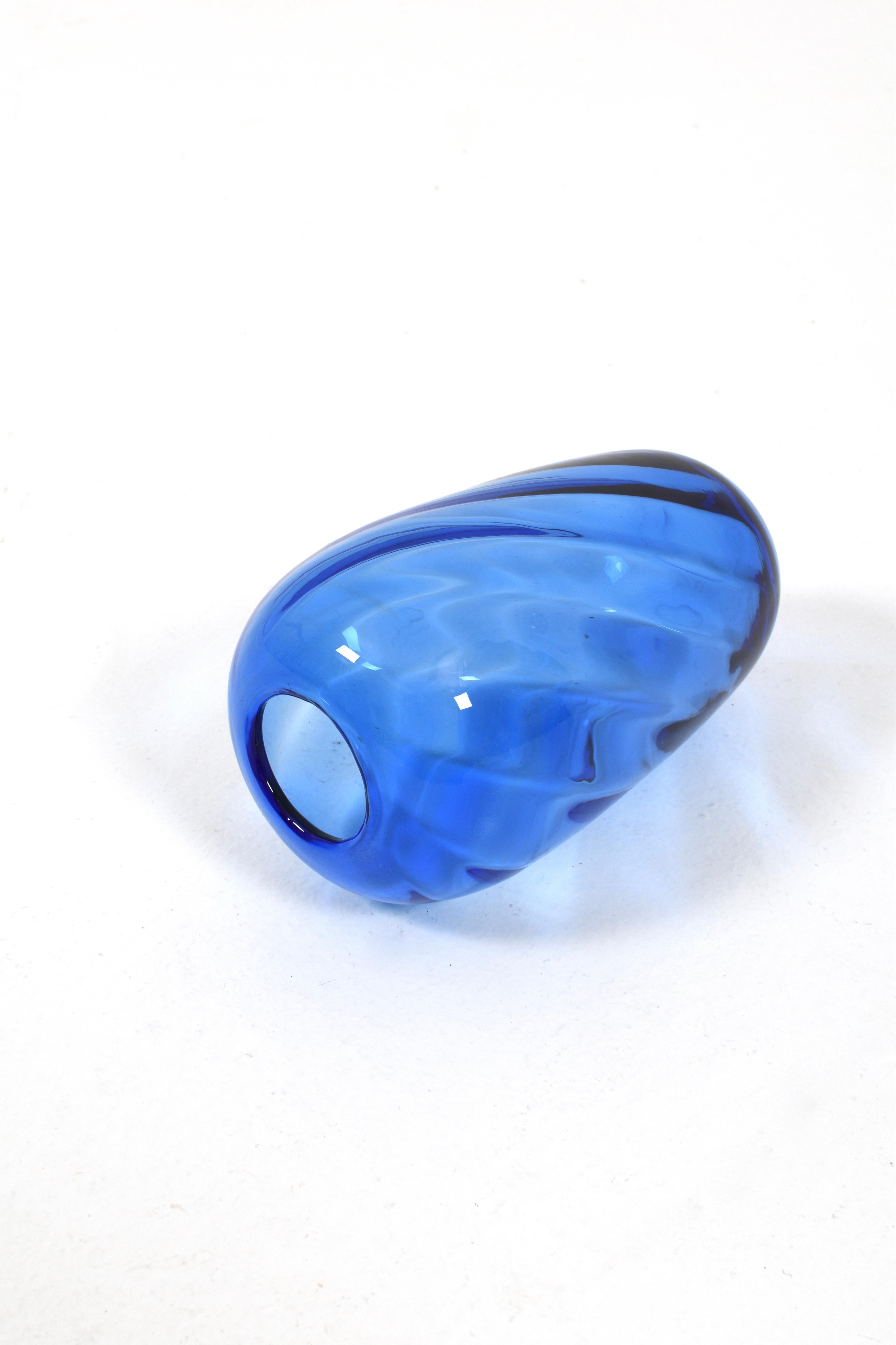 Die blaue Glasvase von Reijmyre Glasbruk ist eine elegante und zeitlose Zierde für Ihr Zuhause. Diese schöne Vase wird von den erfahrenen Glashandwerkern von Reijmyre mit viel Geschick und Liebe zum Detail hergestellt und repräsentiert das Beste der