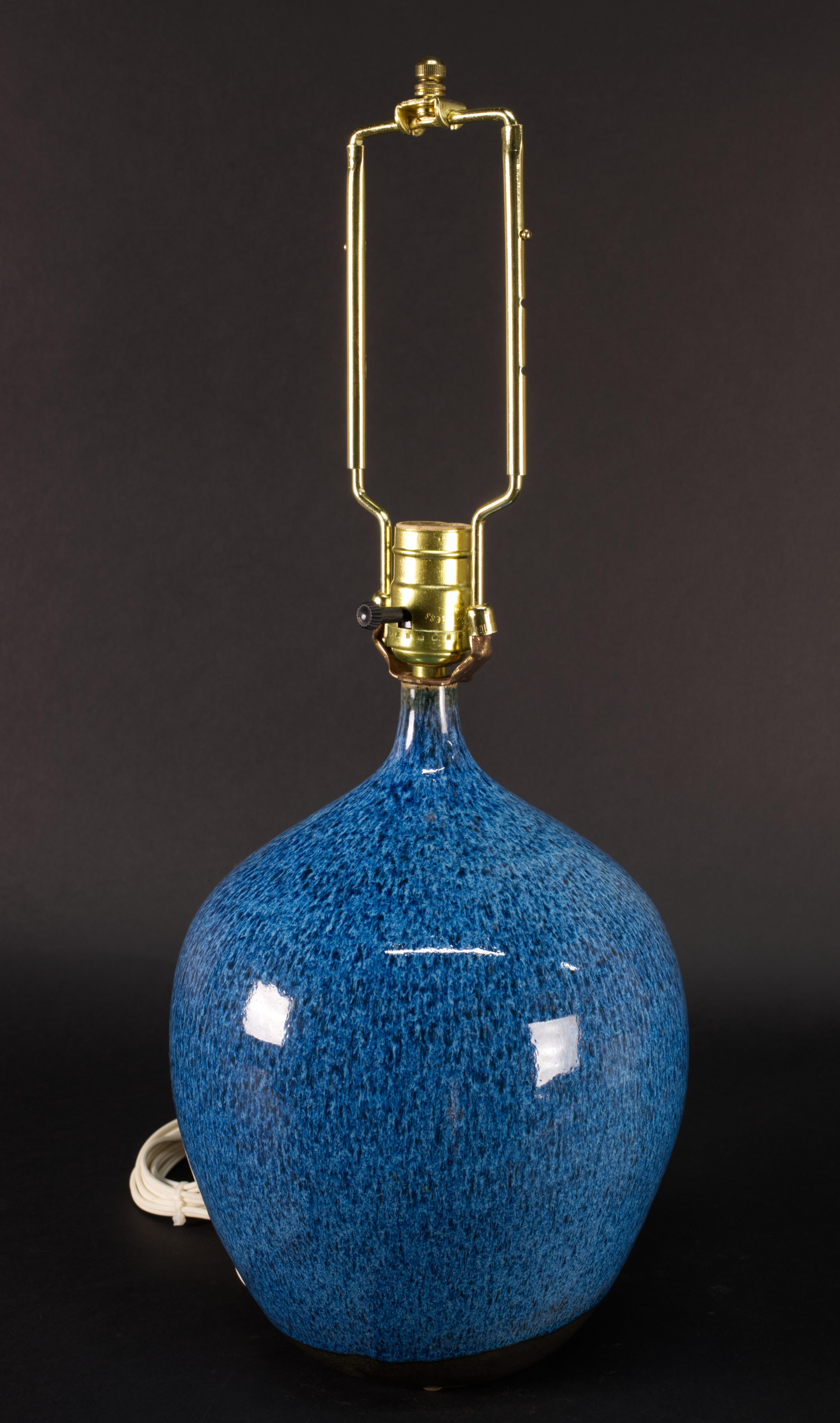 
Die Vintage Studio Art Pottery Keramik Tisch- oder Akzentlampe ist mit glänzender gesprenkelter Glasur in Blautönen verziert. Der Korpus der Lampe wurde von Hand auf einem Rad gedreht. Die markante, auffällige Glasur erzeugt ein organisches, frei