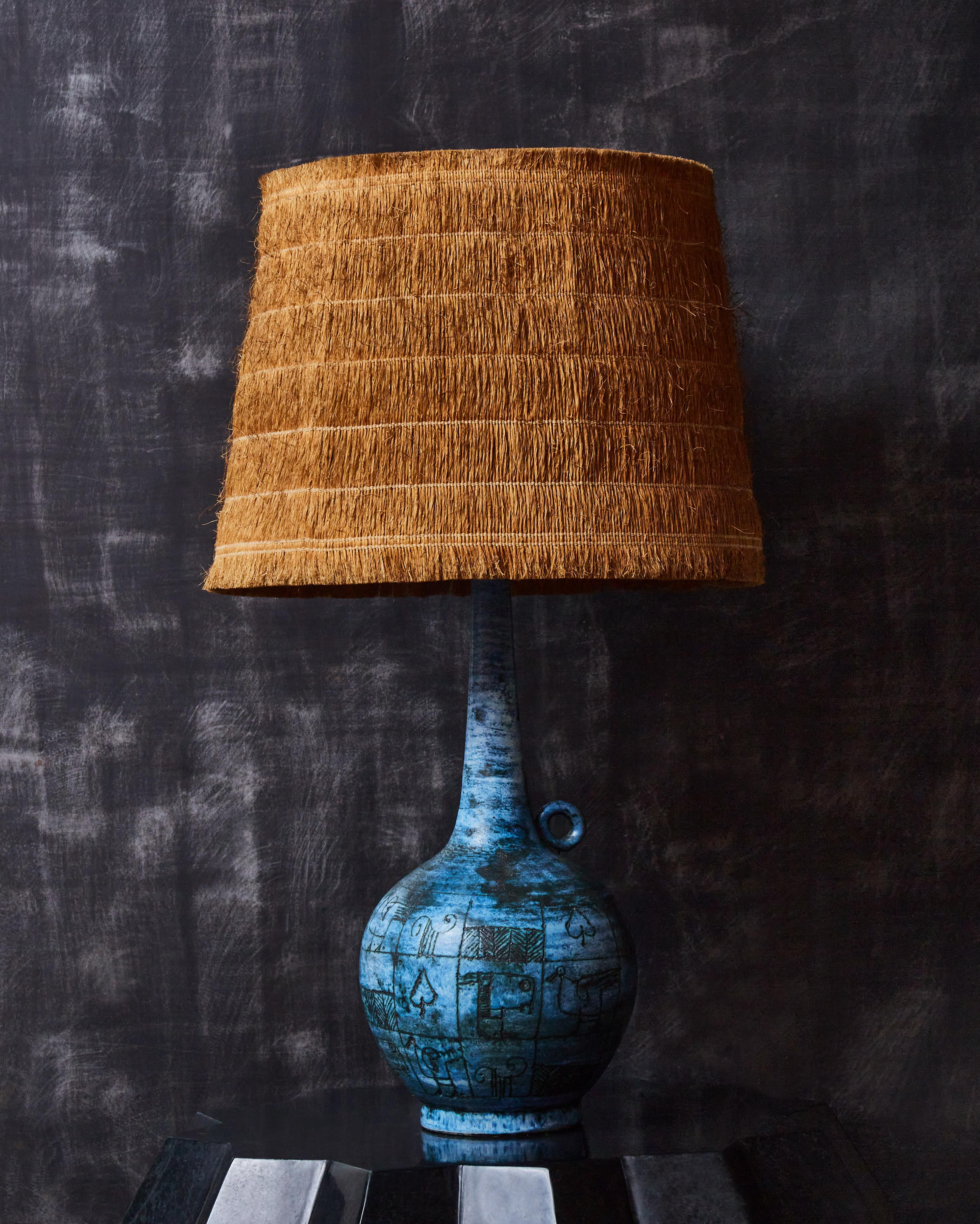 Beautiful jug shaped table lamp in blue glazed ceramic signed by Jacques Blin with Zoomorphic decors. Original lampshade made of coconut fibers. Signed under the base.

Jacques Blin (1920-1995)
Jacques Blin is a well-known French ceramist who
