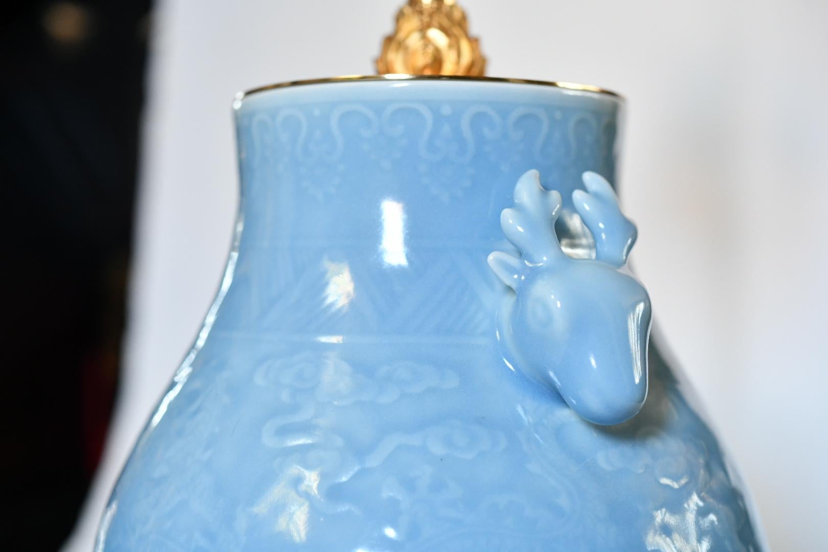 Paire de vases en porcelaine émaillée bleue avec poignées montées comme lampes. Bases en laiton doré finement moulées.
Jusqu'au sommet de la porcelaine : 13.5