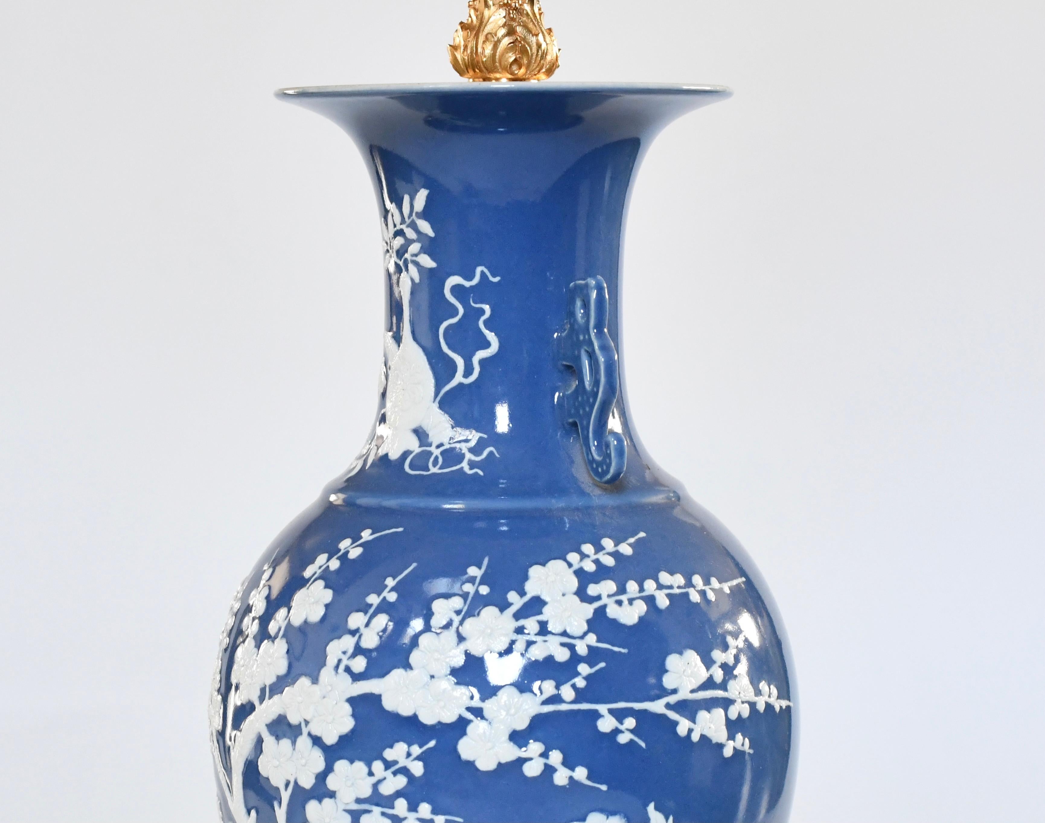 Paire de vases en porcelaine émaillée bleue à décor de fleurs en relief.
Socles et décorations en laiton doré
L'abat-jour n'est pas inclus.