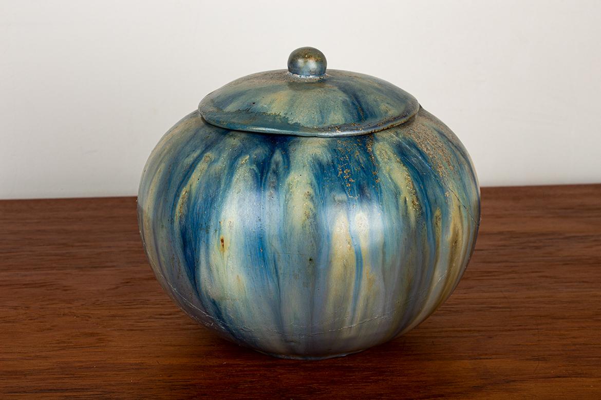 Magnífica maceta Art Déco con tapa muy decorativa, ideal como dulcera, azucarero, bandeja de baratijas u objeto decorativo.
Roger Guérin (1896-1954) fue un ceramista belga del periodo Art Déco, nacido en Jumet y fallecido en Bouffioulx. Estudió con