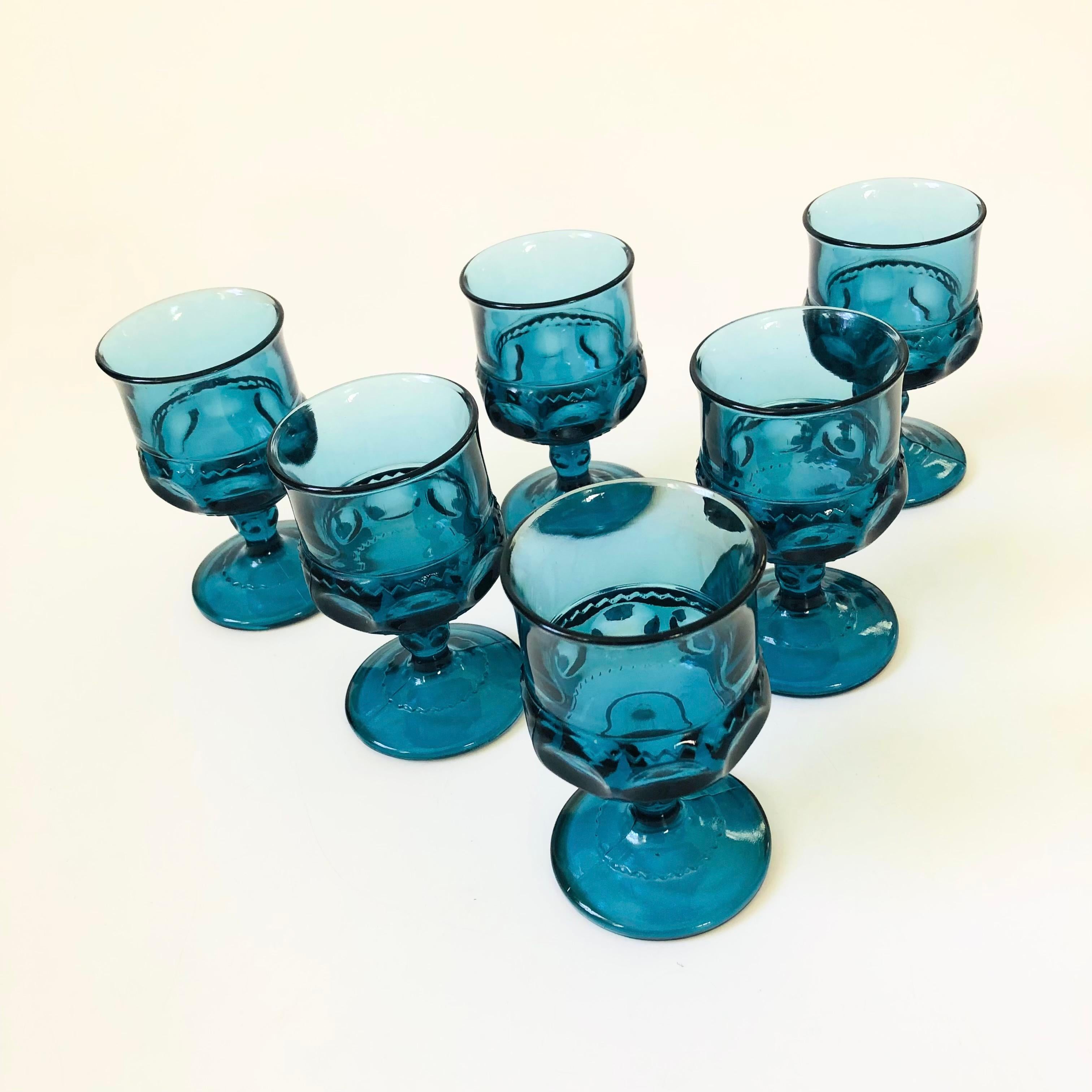 A set of 6 vintage goblets in an ornate design in blue colored glass. Made in the King's Crown pattern by Indiana Glass. Perfect for a small glass of wine or champagne.

