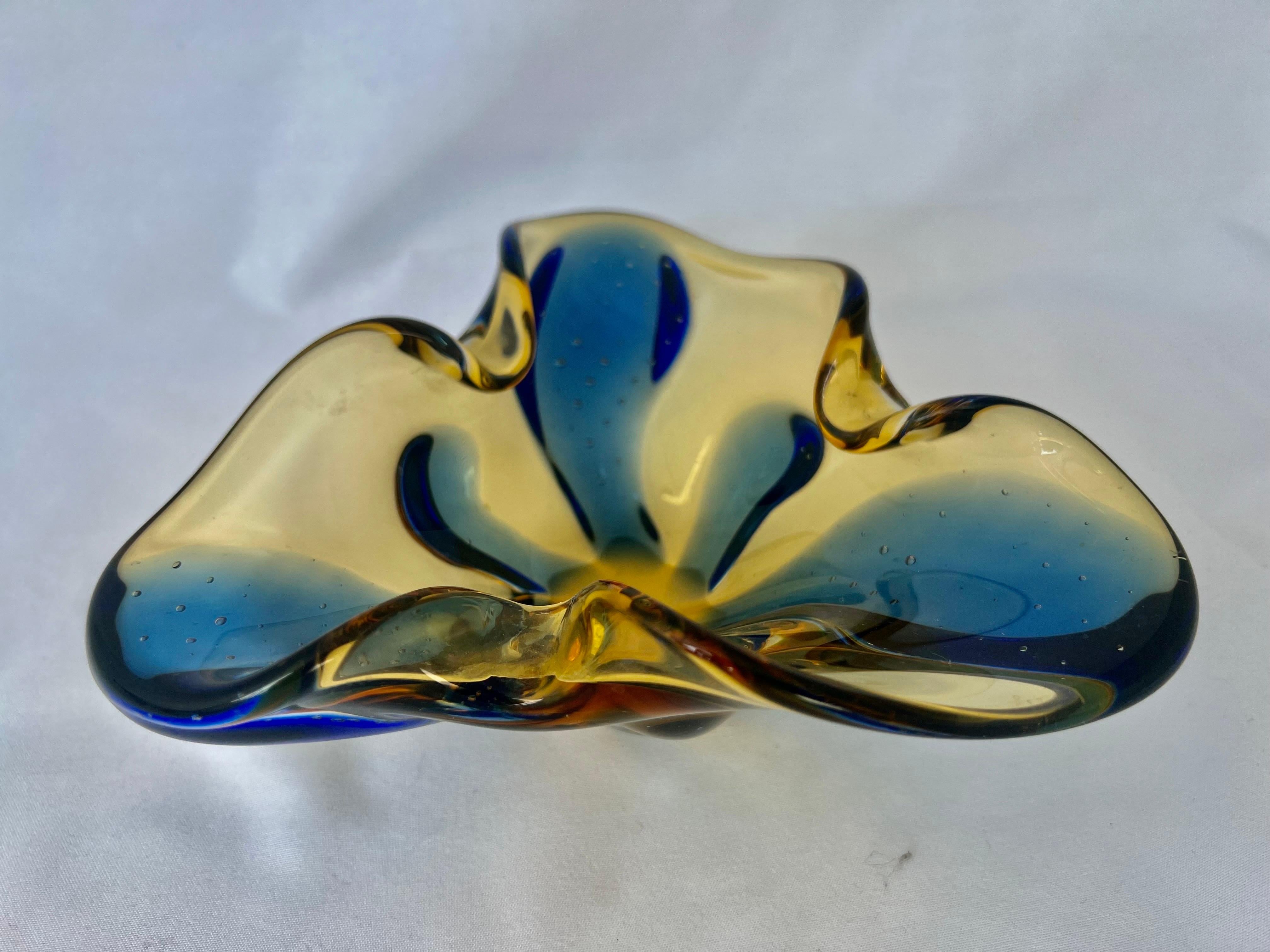 Italian hand blown yellow & blue glass dish.This small piece of art glass looks beautiful on a pile of books. I adds a great pop of color in your decor.
