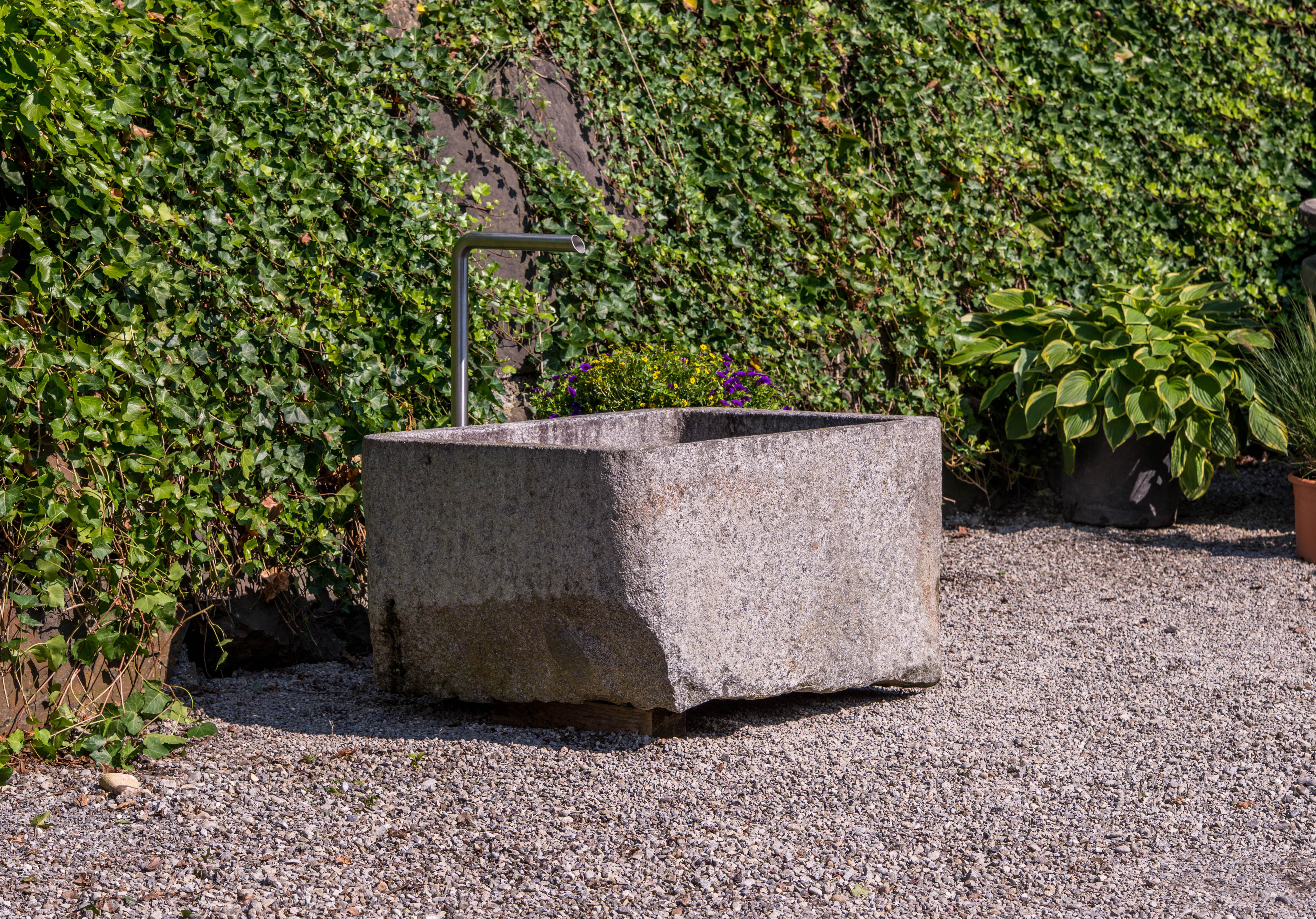 This is an old and used trough from Vichy in France. The fountain was used as a store container, circa 19th century.
The walls from the fountain are thin, so there is a lot of space inside for water. The fountain is made by blue granite.

 