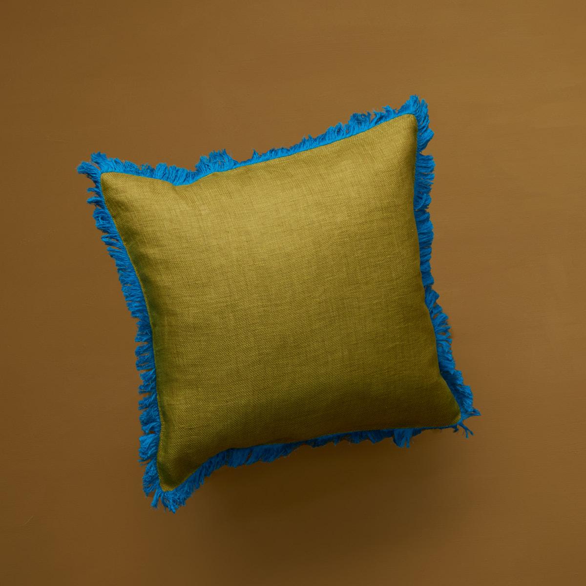 Add a splash of colour to your room with this cushion in a brigth shade of green and blue. The Kadhi cotton fabric is finished with a striking blue grass fringe ending entirely made by hand. Comes without filler, duck feather fillers can be ordered