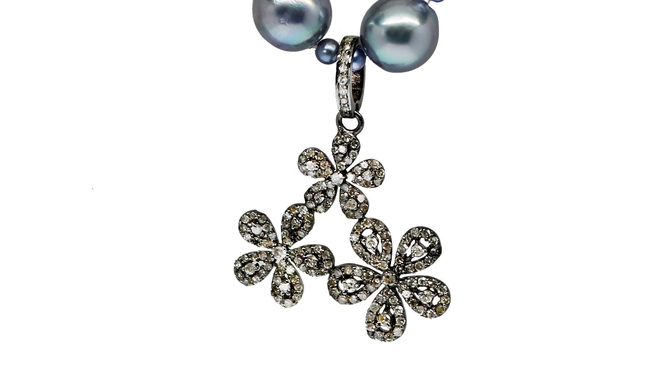 A trio of playful posies kissed with diamonds dangle from this one-of-a-kind pearl necklace. The cheerful sterling silver and diamond charm pendant is featured on a beautiful 21 inch strand of light gray 8-1/4 mm Akoya pearls accented with dyed