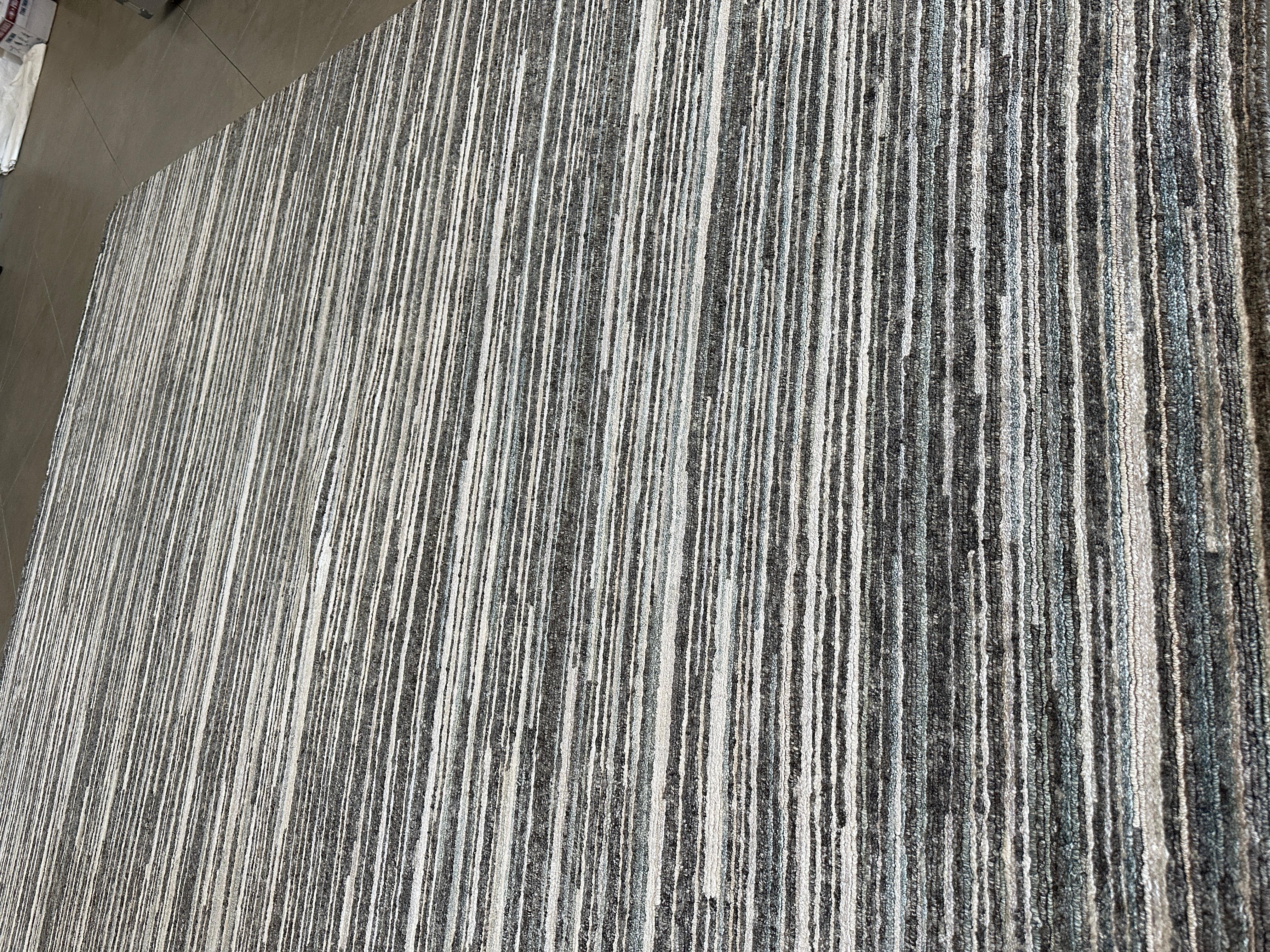 Transform your home with the contemporary elegance of our modern rug, expertly crafted from a blend of 60% wool, 20% viscose, and 20% cotton. Measuring 9.1 ft x 11.11 ft, this rug combines durability, softness, and a touch of sheen to create a piece