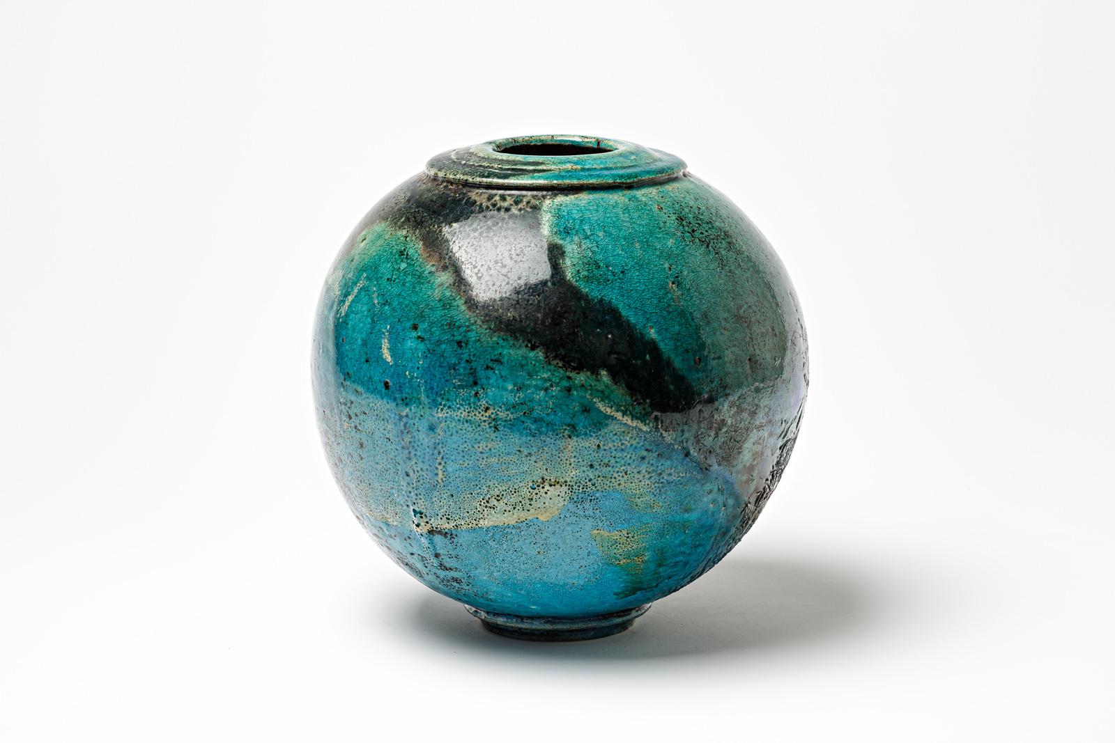 Blue/green and black glazed ceramic ball vase by Gisèle Buthod Garçon. 
Raku fired. Artist monogram under the base. Vers 1980-1990.
H : 9.8’ x 9.1’ inches.
