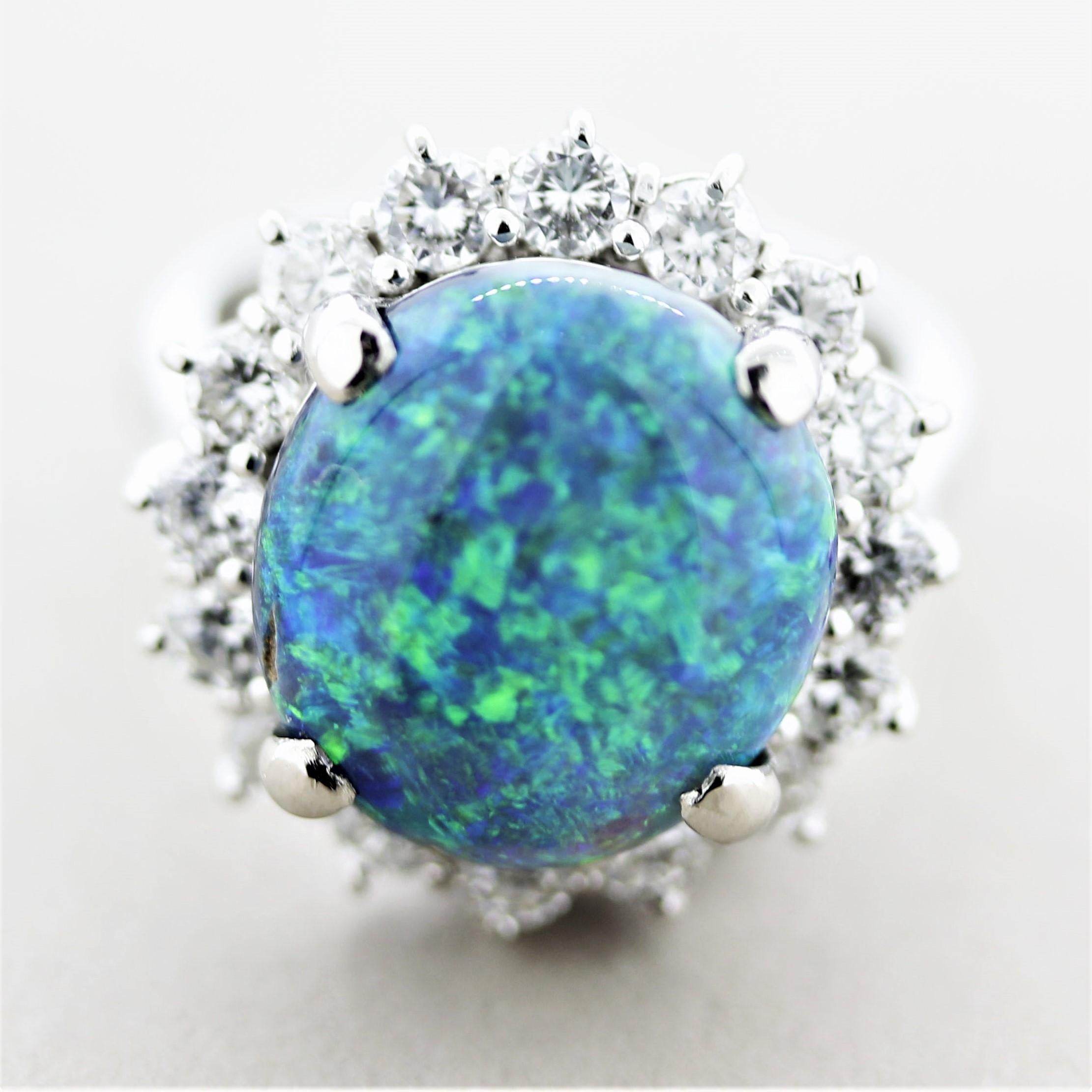 A stunning ring featuring a fine Australian opal weighing 5.66 carats. It shows excellent play of color with bright intense colors of green and blue across the entirety of the opal. It is accented by 1.18 carats of round brilliant-cut diamonds