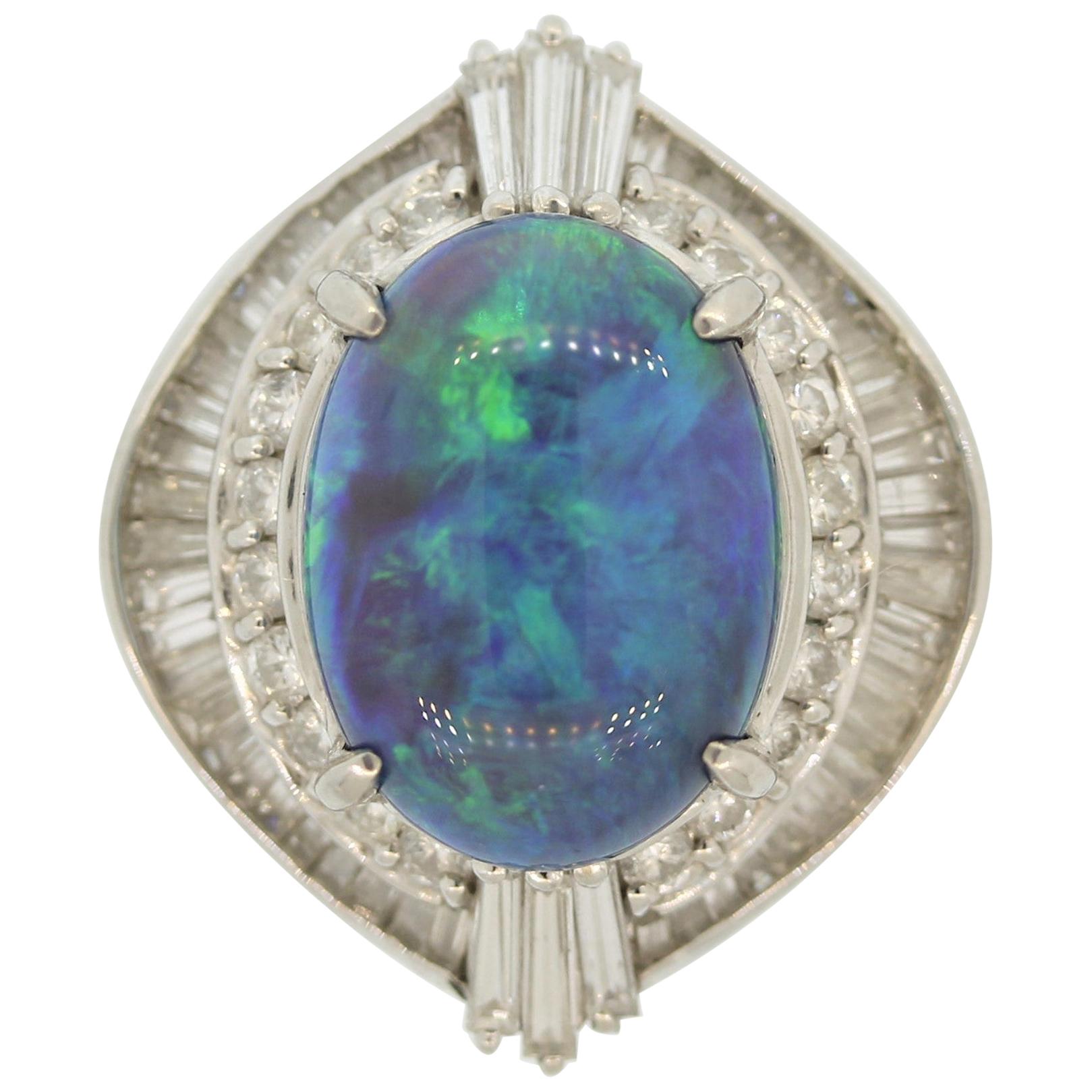 A classic Australian opal weighing 5.17 carats takes center stage. It has great play of color as the opal shows bright and strong flashes of blue and green across the entire stone. It is accented by 1.30 carats of round brilliant and baguette cut