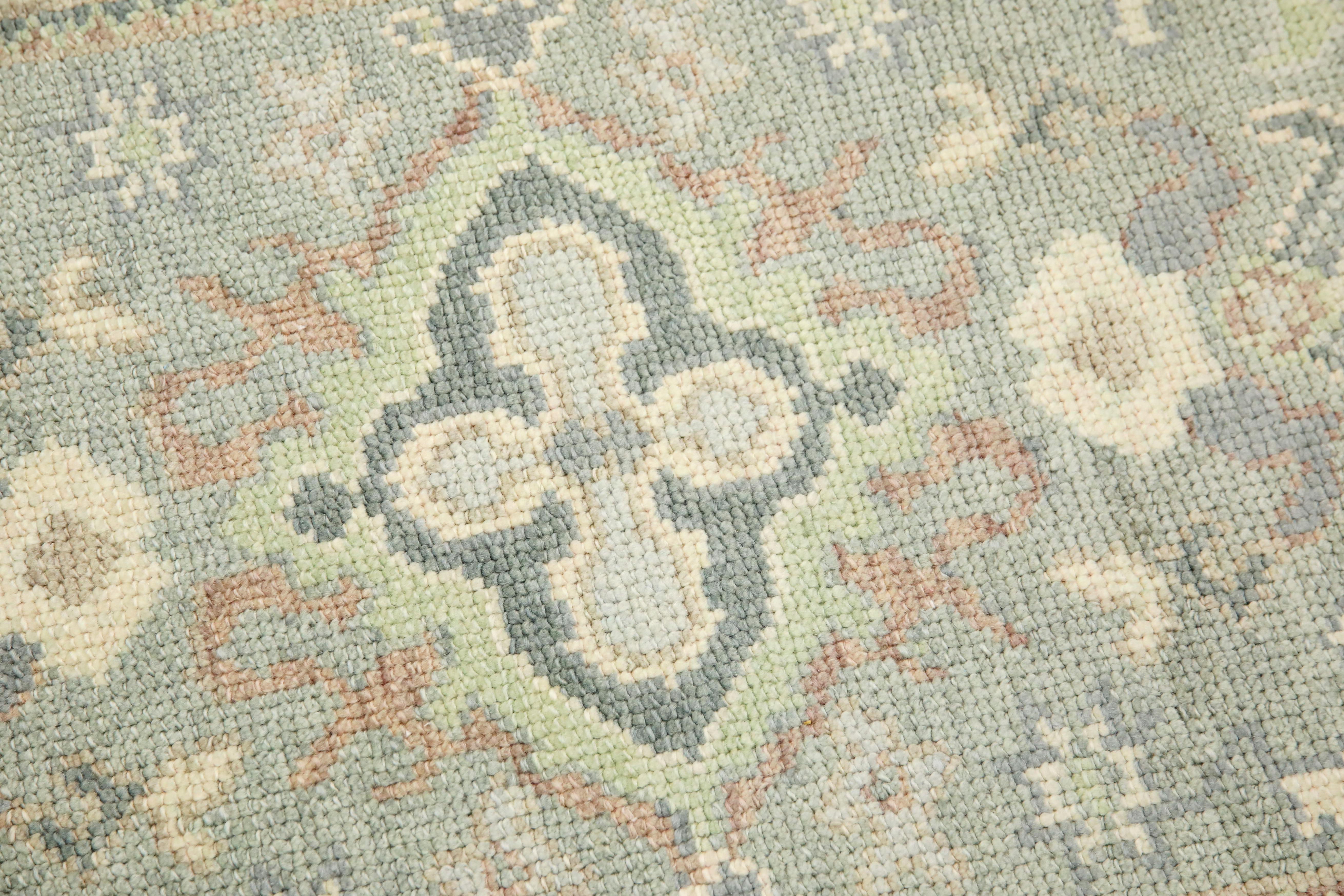 This modern Turkish Oushak rug is a stunning piece of art that has been handwoven using traditional techniques by skilled artisans. The rug features intricate patterns and a soft color palette that is achieved through the use of natural vegetable