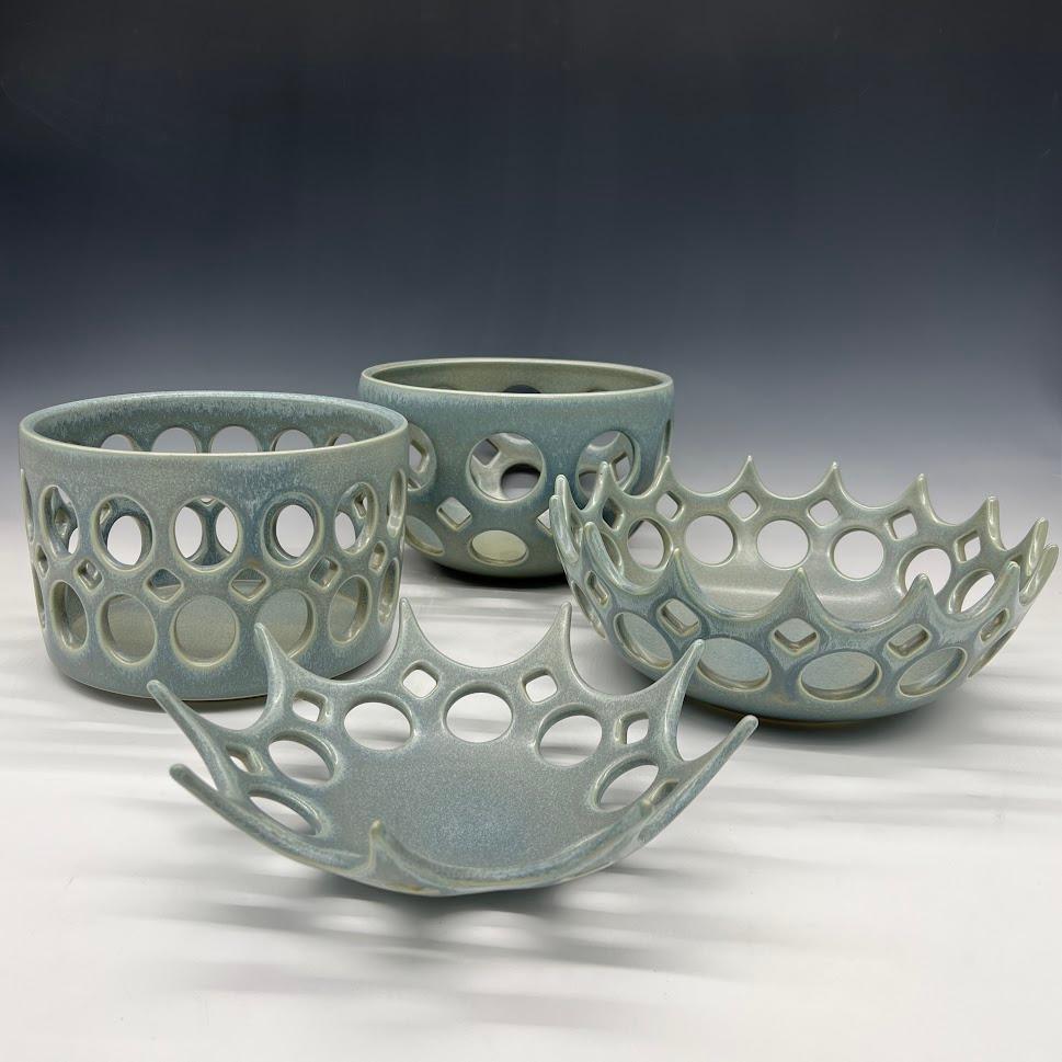 Inspired by Mid-Century Modern design, this bowl is wheel thrown and hand pierced stoneware with satin glaze that breaks from blue to green to grey. Small holes are created when the clay is still wet and then each hole is painstakingly enlarged and