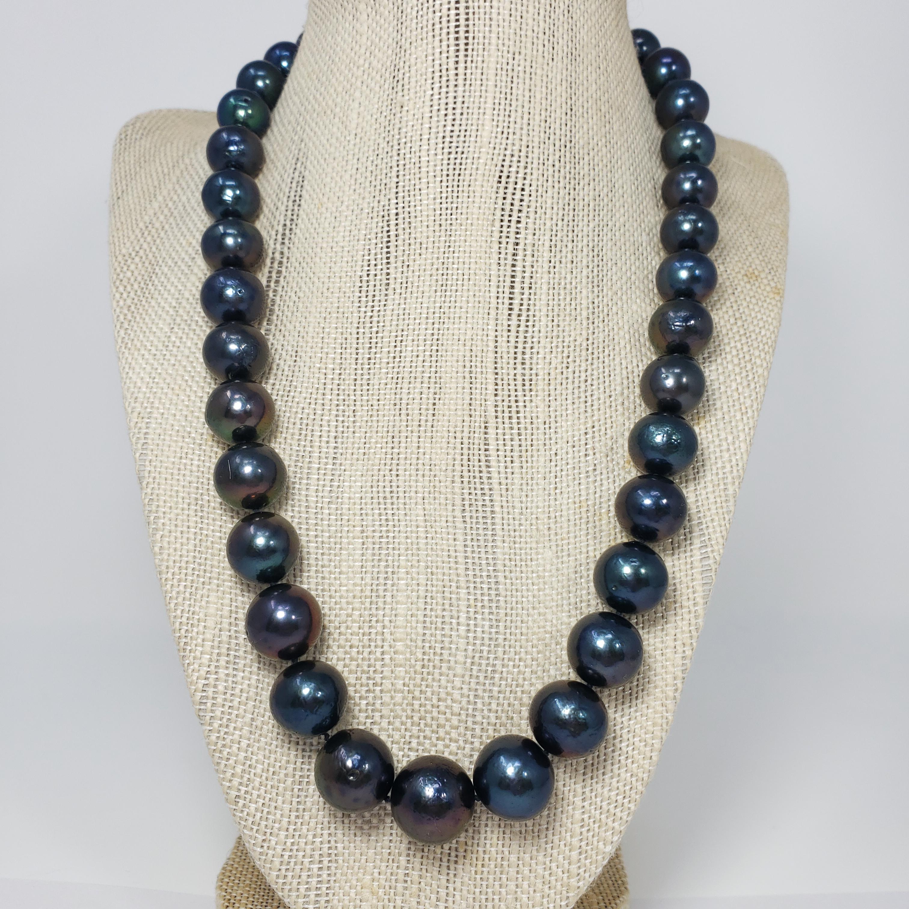A sophisticated strand of grduated Tahitian pearls with a dark blue-green tint, accented with a sterling silver clasp. This necklace is sleek and sophisticated!

Hallmarks: 925
Pearls range from 11.6mm to 15mm in diameter