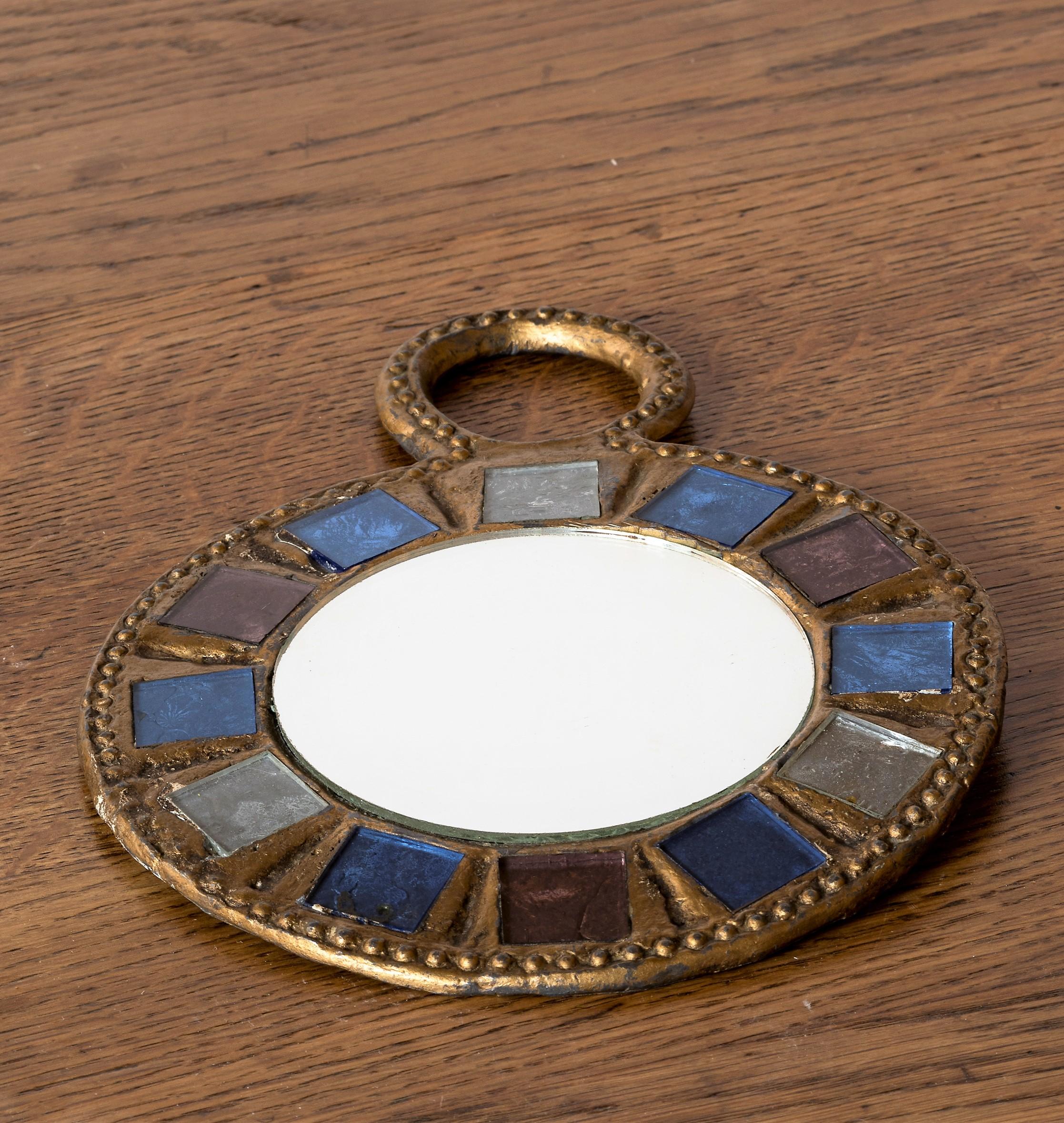 Metal wall mirror or hand mirror with green and blue talosel inlays by Irina Jaworska ( Line Vautrin School ), France 1970s.
Lead framed gilt mirorr with pressed pattern and talosel inlays in shades of green and blue surrounding a round golden