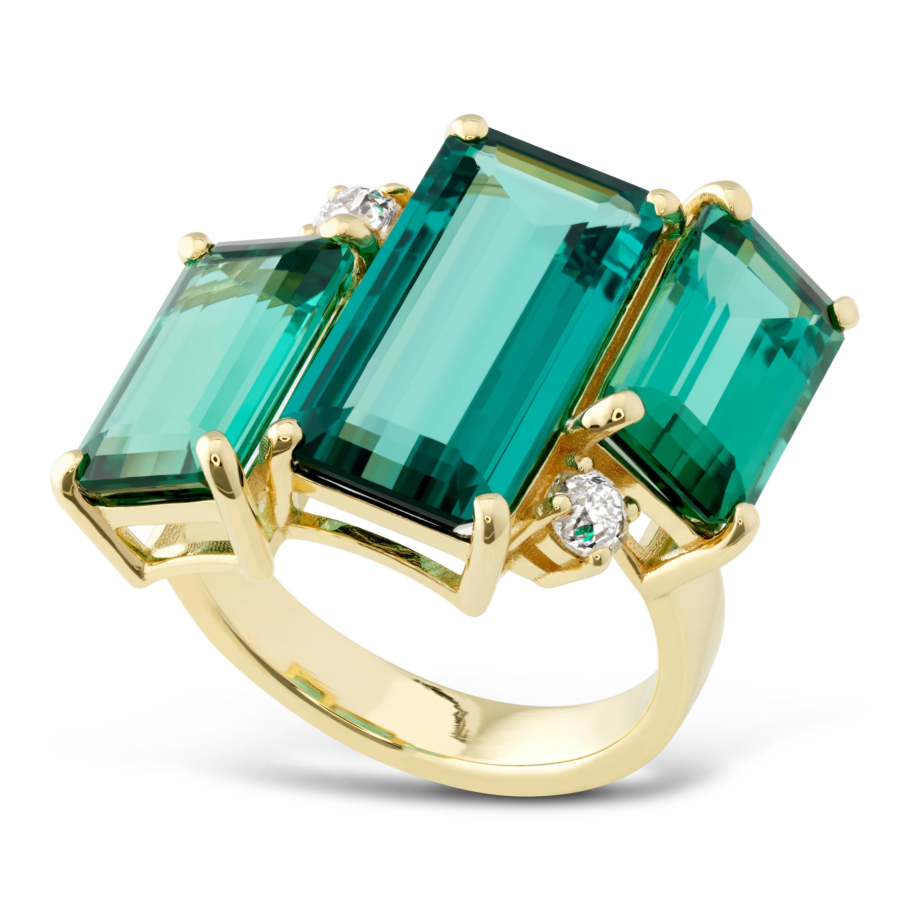 Cocktail ring set with 11.06 total carats of exceptional blue green tourmaline set with .32ct of diamonds in 18k yellow gold.  This ring sparkles at every turn.   The three step cut tourmalines are crystal clear with beautiful light refraction.  