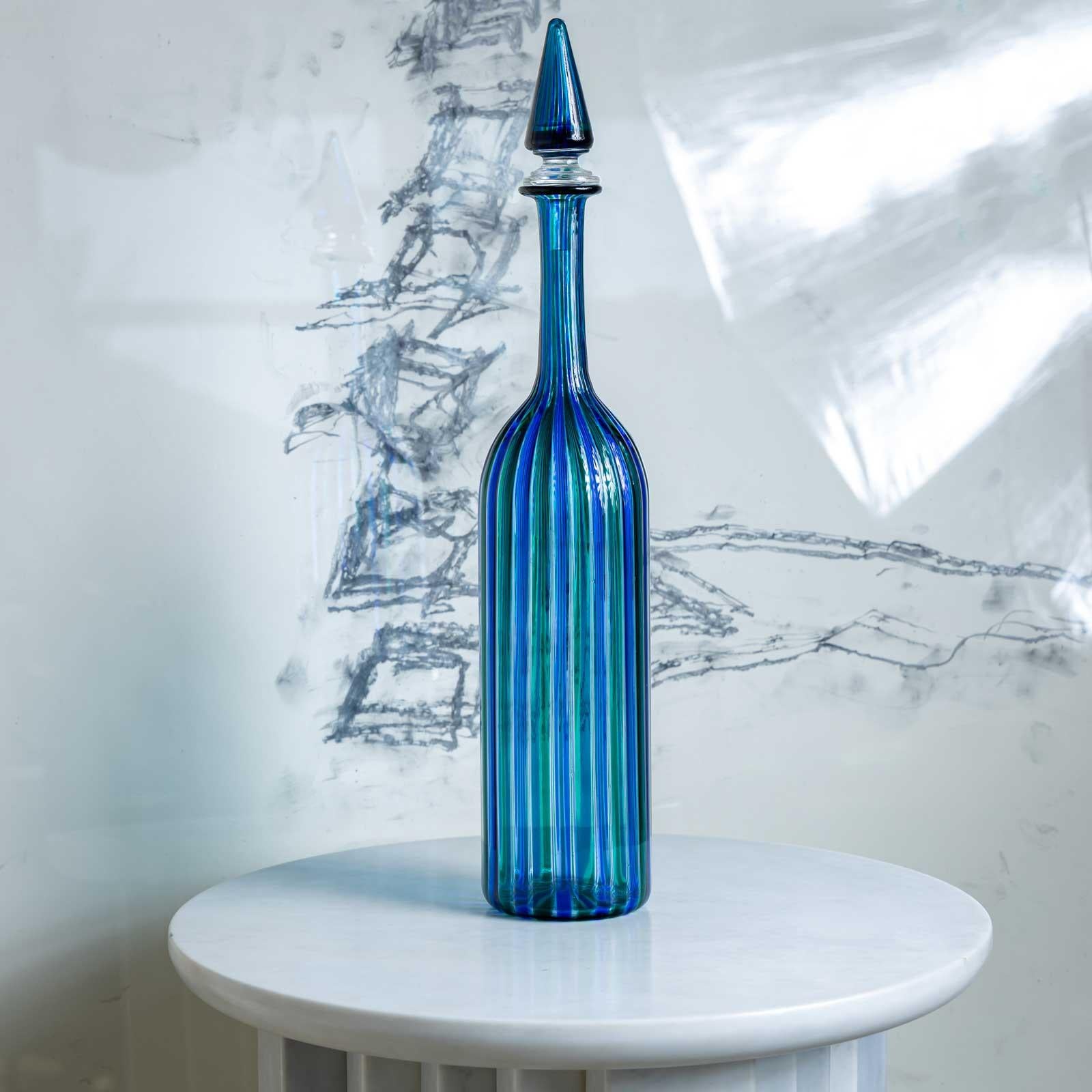 Grande caraffa con tappo conico e parete cilindrica liscia con decorazione a strisce blu-verdi. Firmato sul fondo: Venini Italia 79.