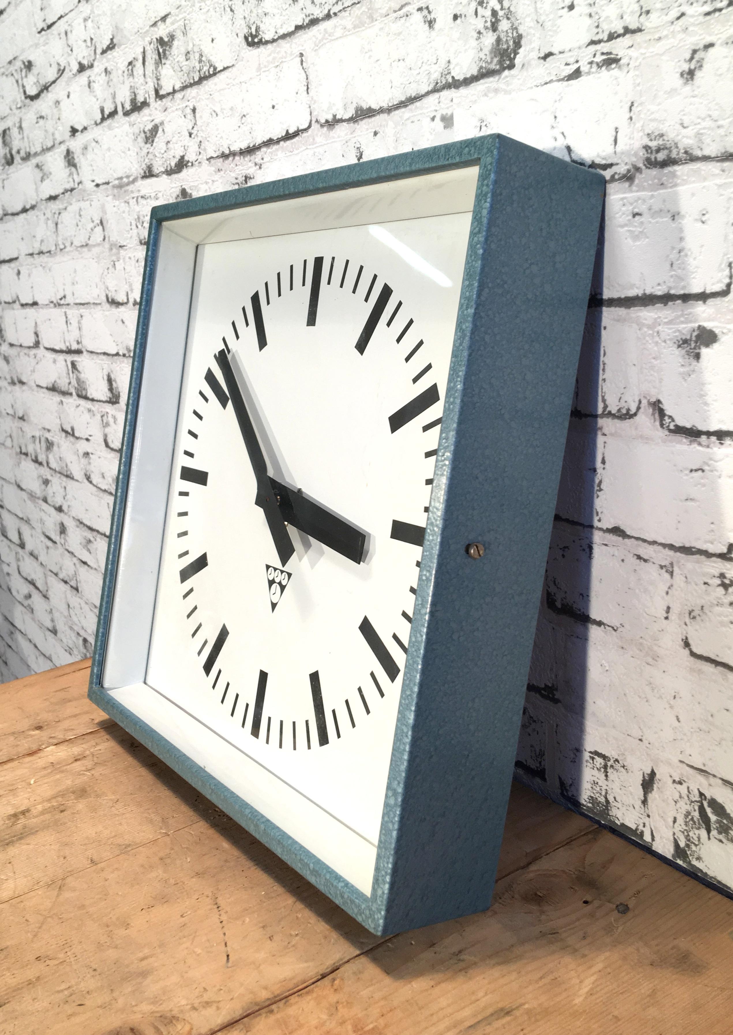 Diese Uhr wurde in den 1970er Jahren von Pragotron in der ehemaligen Tschechoslowakei hergestellt und in Fabriken:: Schulen und Bahnhöfen eingesetzt. Sie hat einen blau-grau gestrichenen Korpus mit Klarglasabdeckung. 
Der Artikel wurde in ein