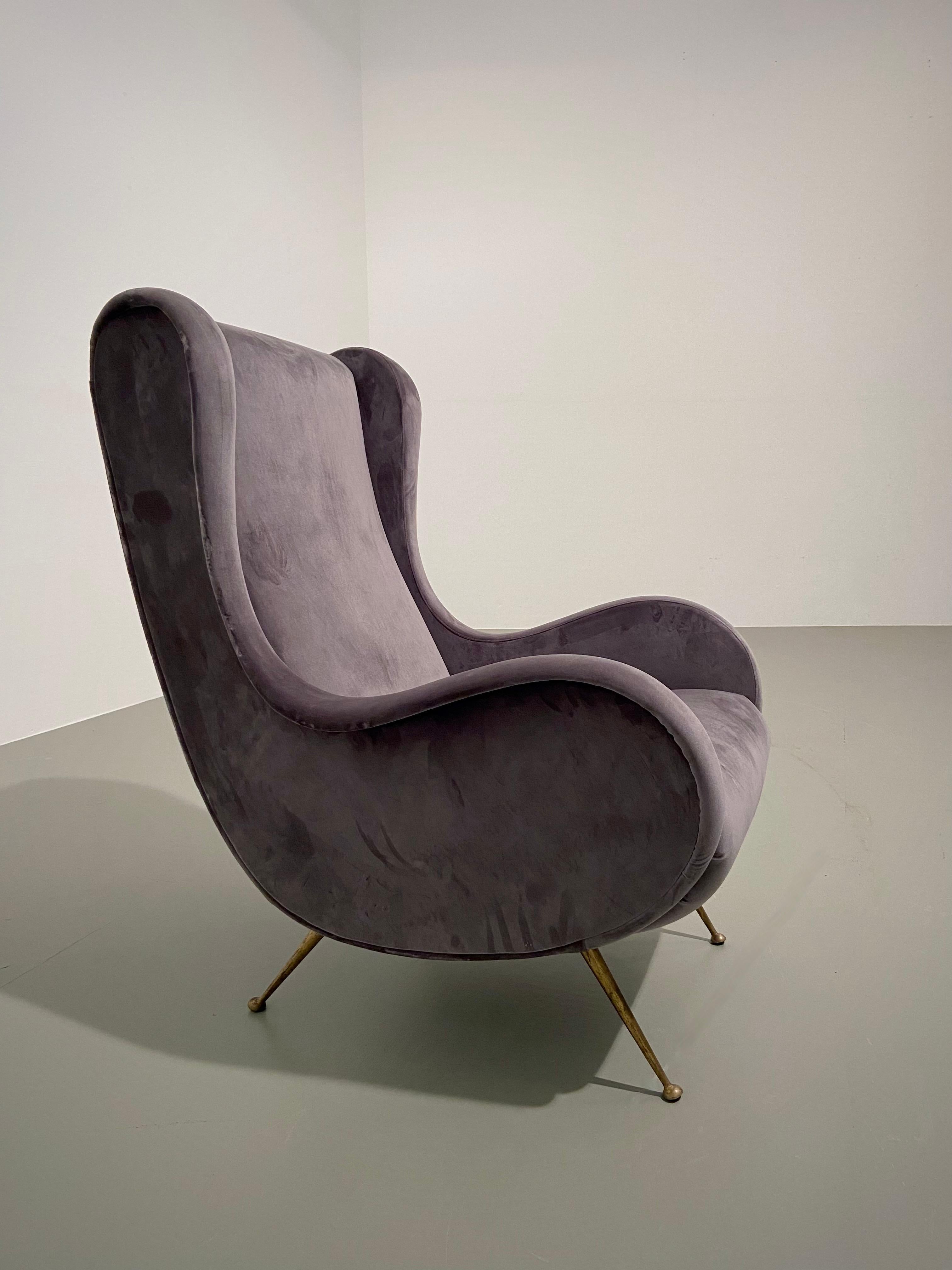 A recently reupholstered lounge chair with long brass legs. Great curves and shapes and the colour of the recent upholstery is grey / blue. The chair very much resembles the 'Bergere' chair by Gio Ponti and the legs clearly show that it's from that