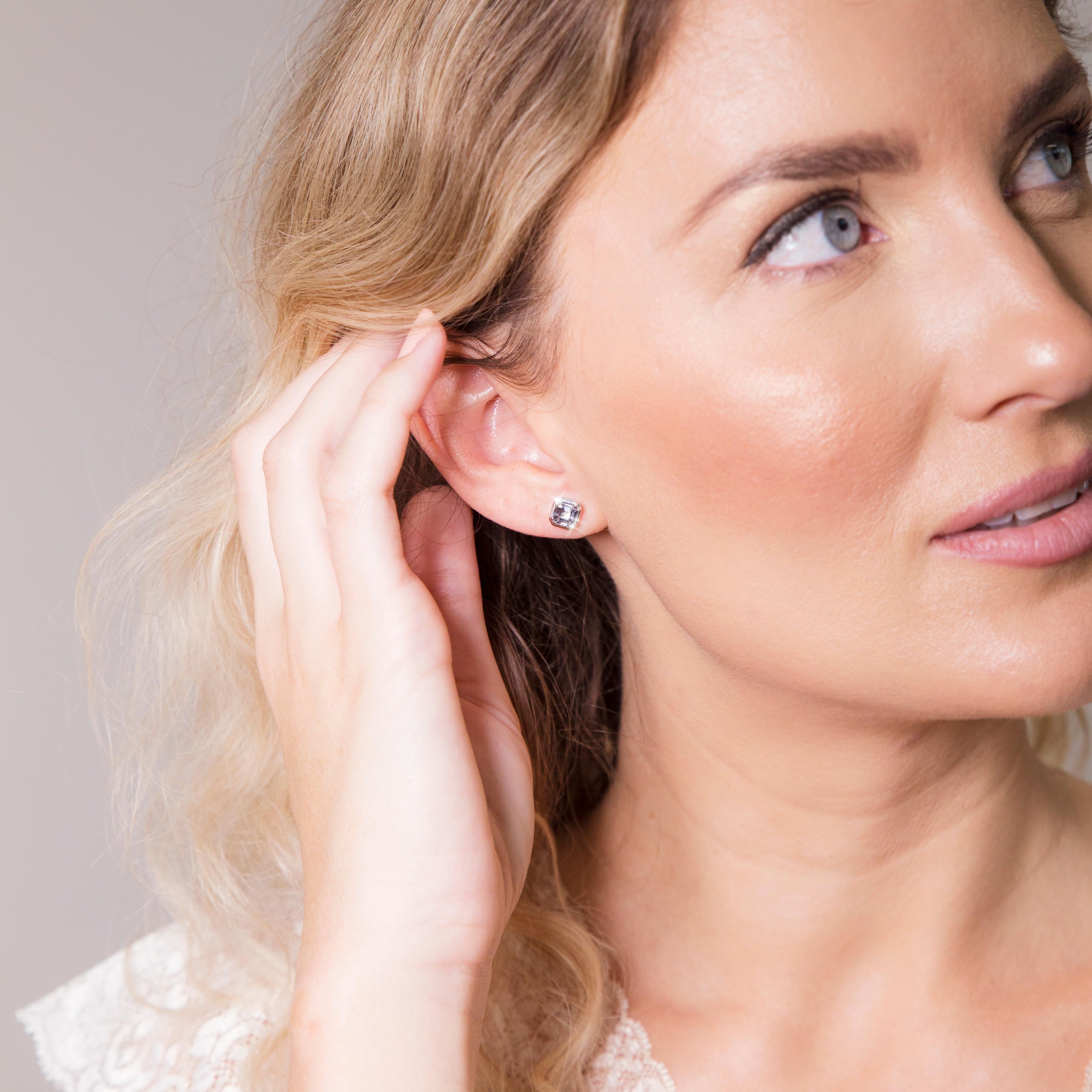 Diese verführerischen Ohrstecker aus 9-karätigem Weißgold sind mit einem eleganten lila-grauen Spinell im Asscher-Schliff versehen, der in einer wunderschönen, sich verjüngenden Lünettenfassung sitzt. Wir haben diese zierlichen Ohrstecker
