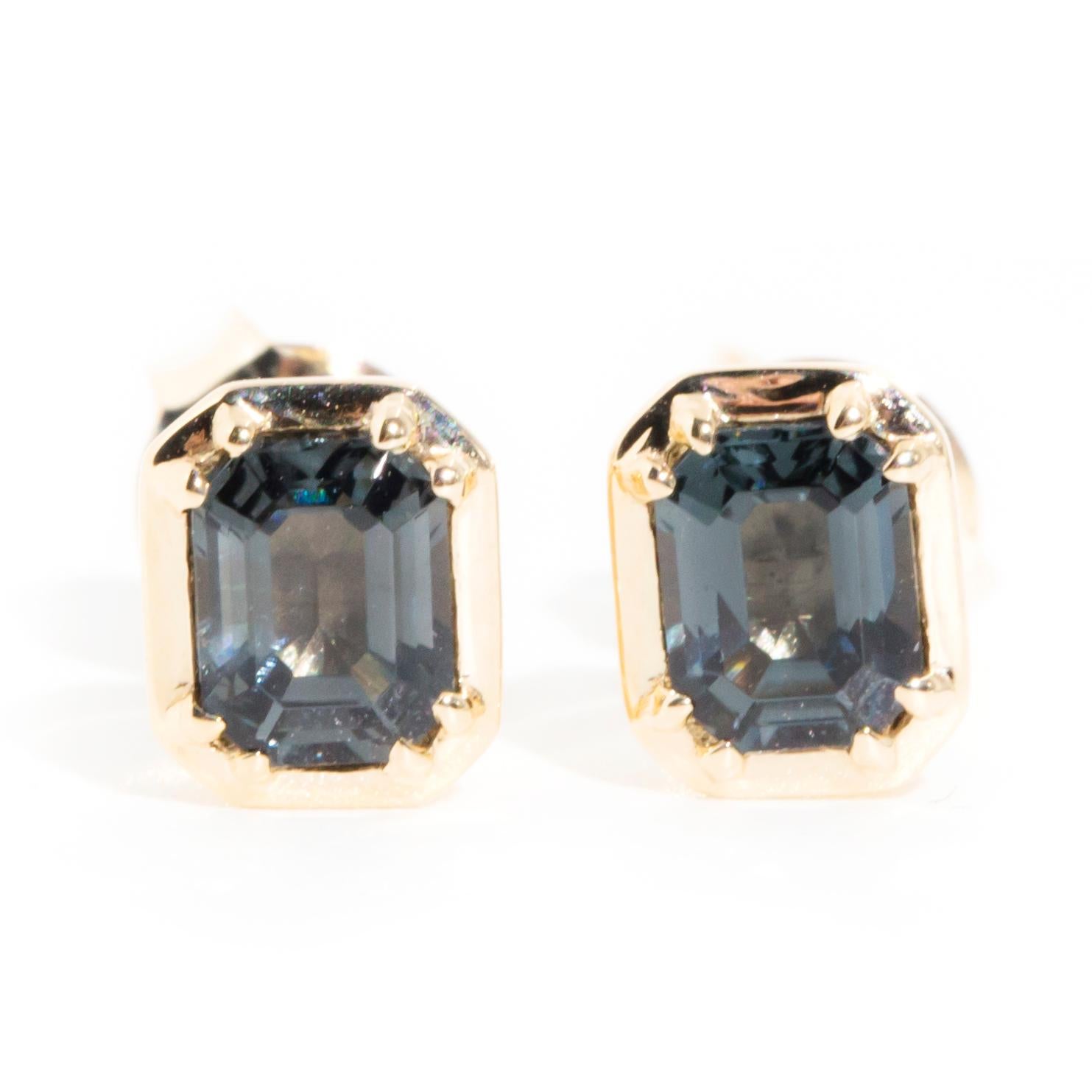 Crafted in 9 carat yellow gold, these alluring contemporary stud style earrings each feature a wonderous blue grey emerald cut spinel sitting in a gorgeous tapered bezel setting. We named these petite studs The Elsa Earrings. She fits comfortably to