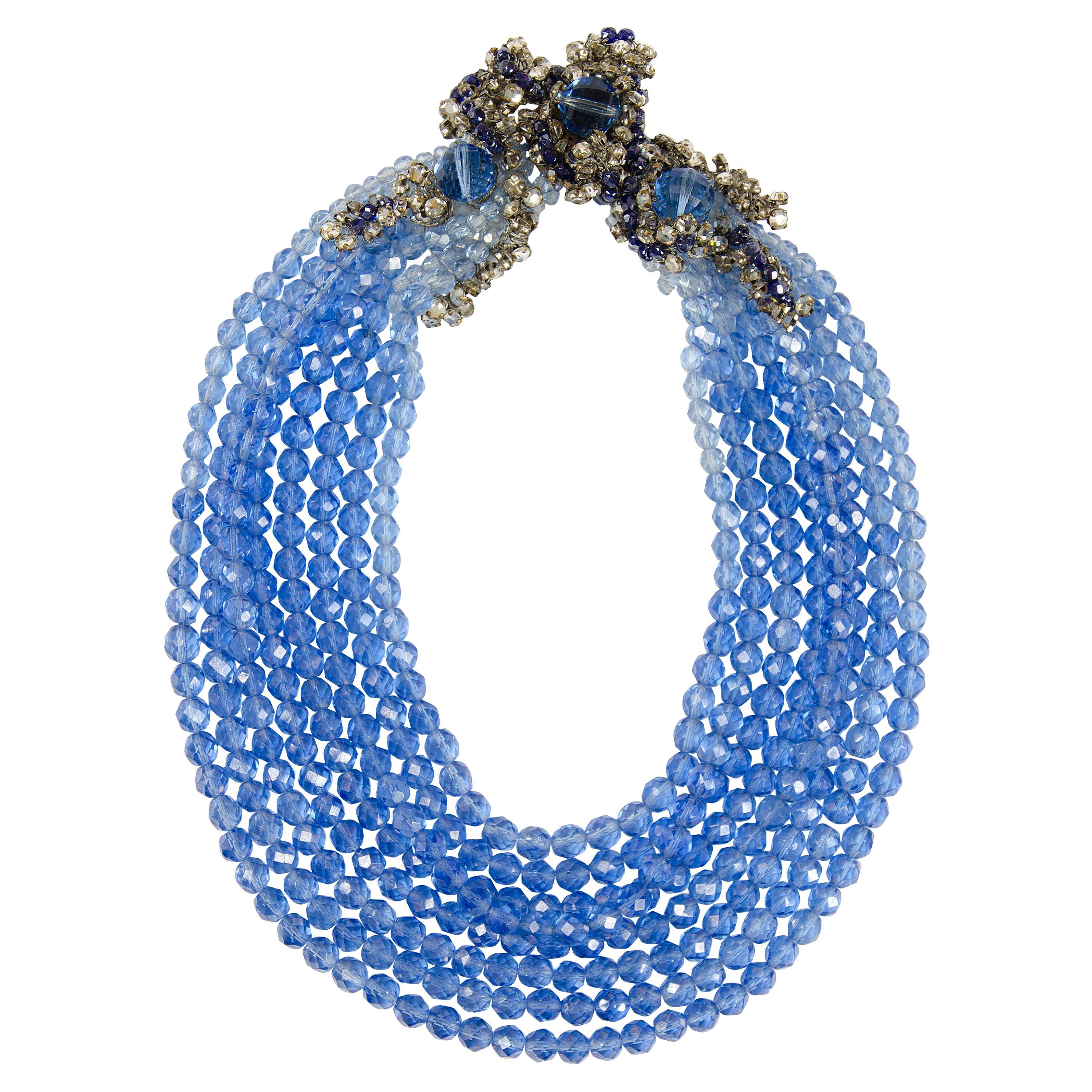 An exceptional and highly stylish graduated row necklace by Coppola e Toppo, composed of graded blue half crystal beads, with a sumptuous side decoration, composed of leaf shape elements, made of silver plated wire, paste rose montees and larger