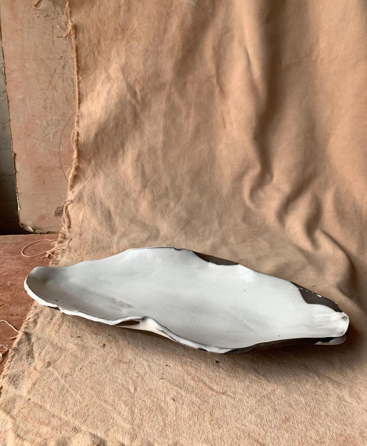 Hand-built free-form long shallow platters custom-designed for Dan Barber's Blue Hill at Stone Barns restaurant. Variegated glossy white glaze on dark brown clay. Equally well suited to display as to serving.

Food safe; Hand-washing