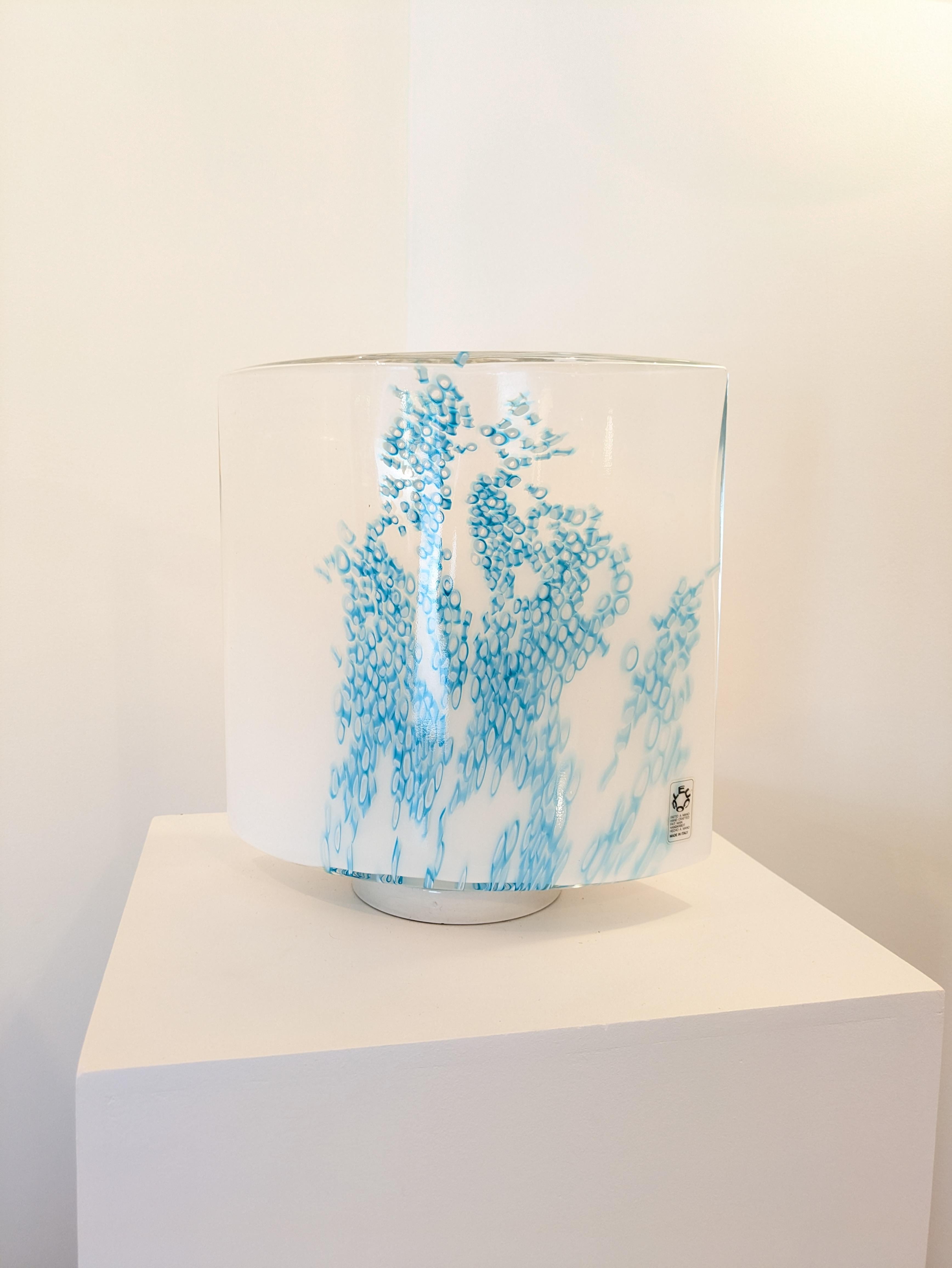 Lampada da tavolo in vetro soffiato di Murano realizzata a mano, prodotta da Leucos negli anni '80. 
È stato disegnato da Rosanna Toso nel 1982 e originariamente prodotto in due dimensioni nei colori blu/verde, rosa e bianco.

La base è in metallo