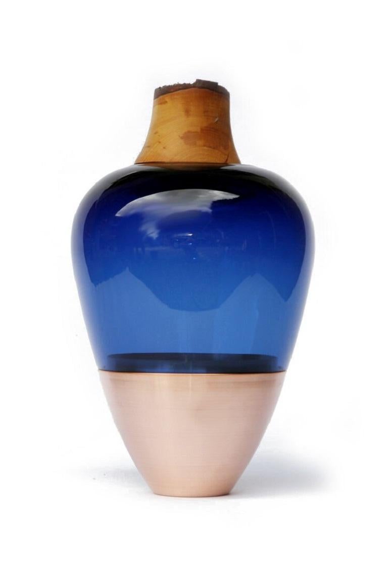 Blue India Vessel I, Pia Wüstenberg
Dimensions: D 20 x H 38
Materials: glass, wood, copper

Handmade in Europe, by individual craftsmen: handblown glass (Czech Republic), hand spun metal, (England), hand turned wood (Finland). The materials then