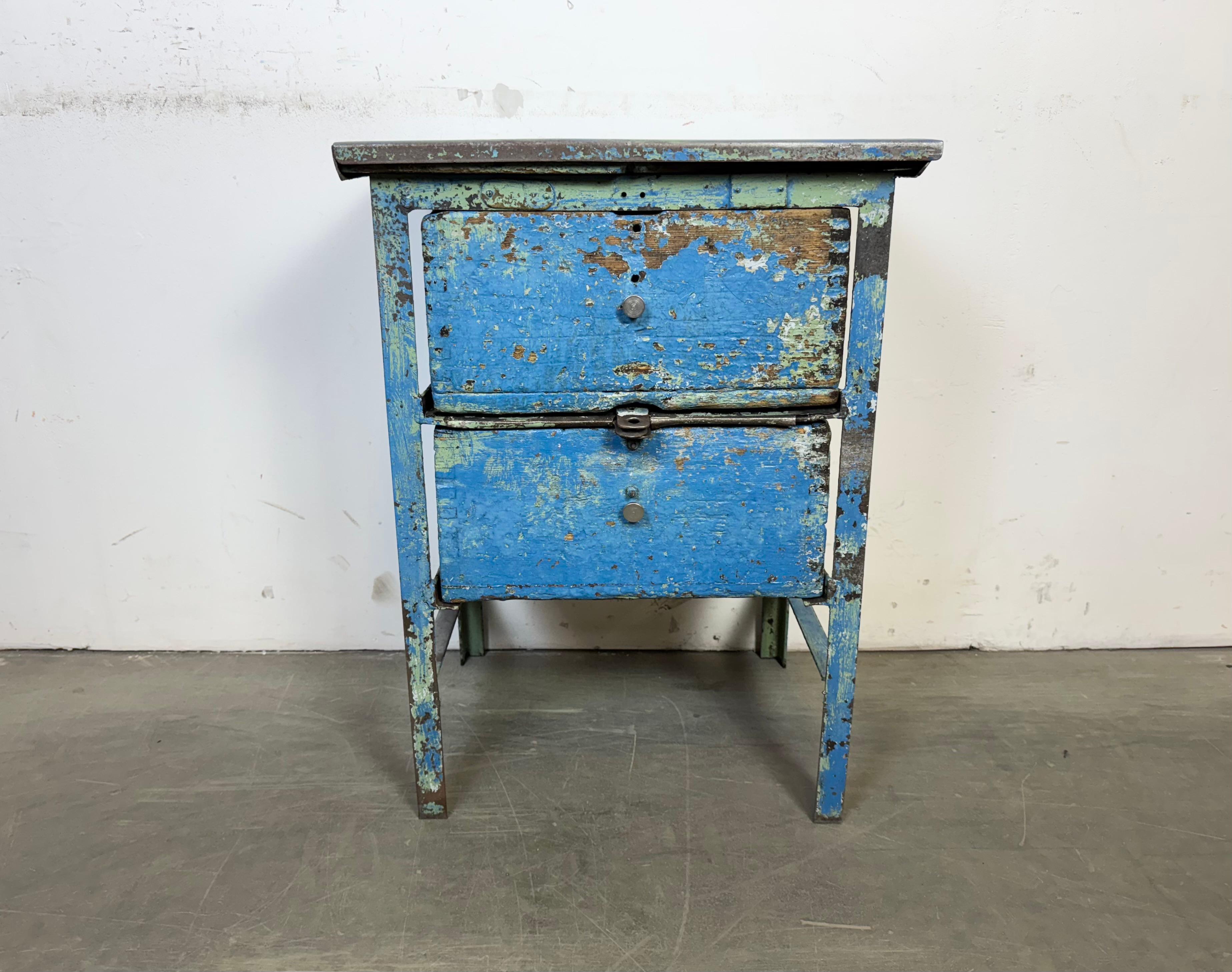 Questa cassettiera industriale vintage è stata realizzata nell'ex Cecoslovacchia negli anni Cinquanta. Presenta una struttura in ferro, un piano in metallo e 2 cassetti in legno. 
Dimensioni del cassetto :
- Larghezza 37 cm, profondità 32 cm,