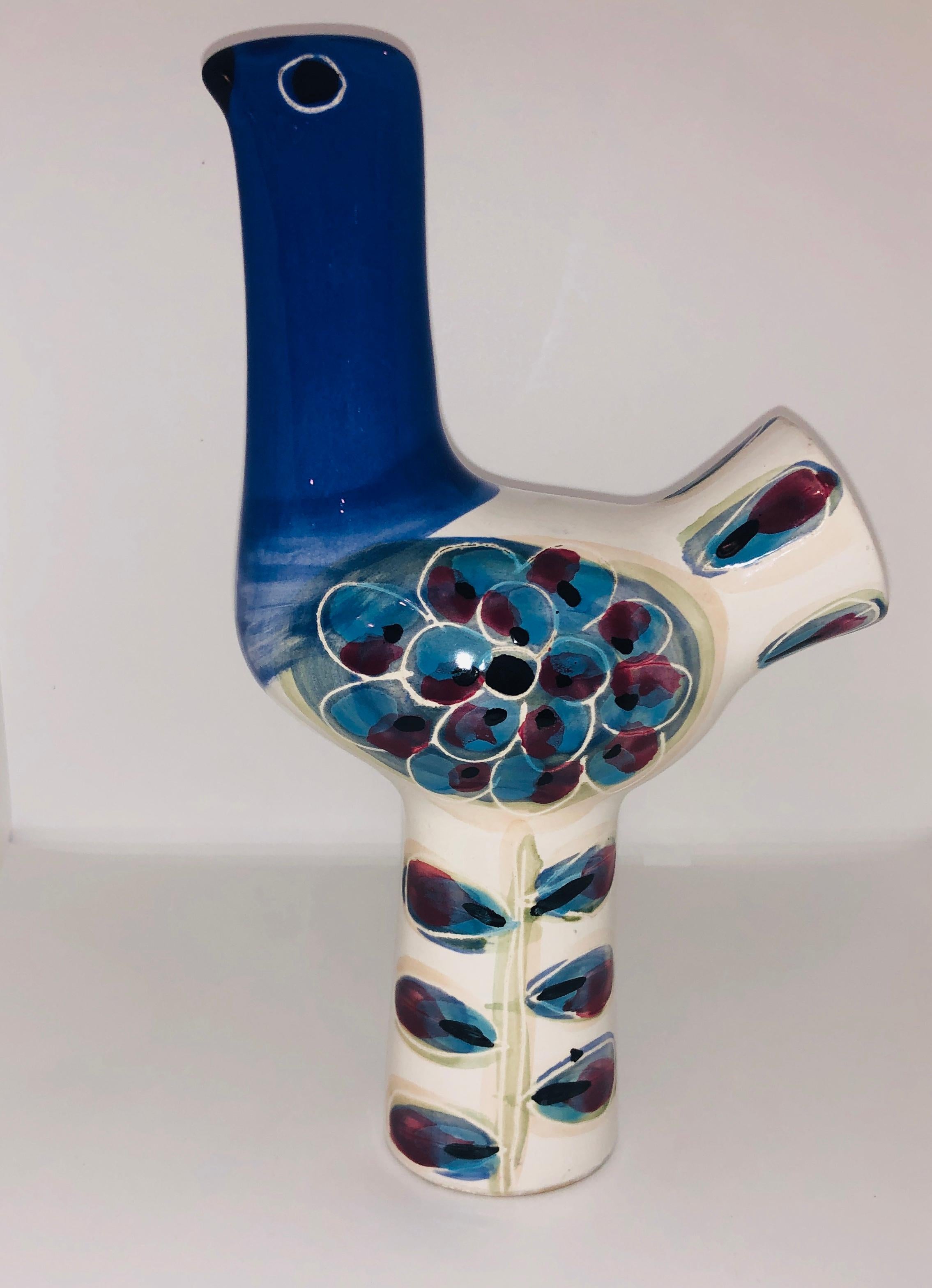 Offered is a Mid-Century Modern Italian glazed ceramic zoomorphic (avian / bird) in ivory / off-white background with a blue, red and black design, sculpture. The color on the ceramic bird sculpture / figurine adds a blue that goes from a deep blue