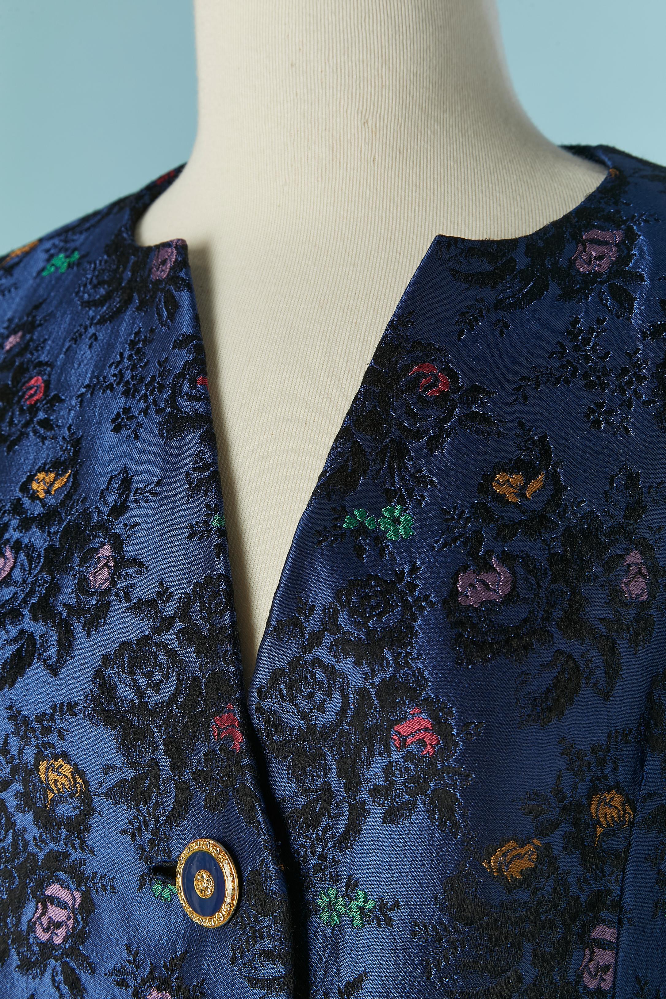 Tailleur jupe en jacquard bleu. Pas d'étiquette de composition du tissu mais la doublure est probablement en acétate. Fermeture par bouton et boutonnière sur le milieu du devant. 
TAILLE M